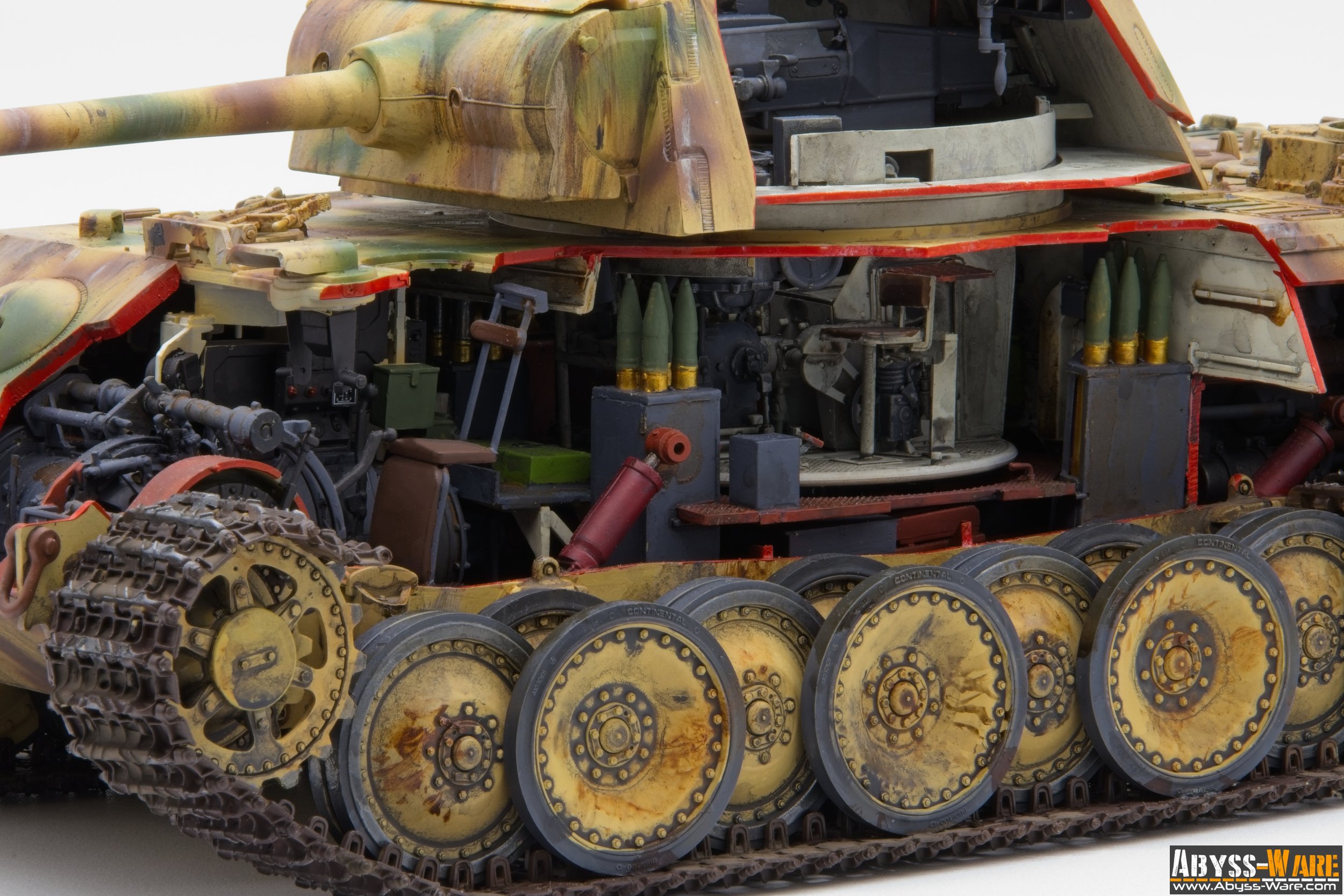 Close-up of a detailed toy tank showing internal mechanical parts, tracks, and ammunition, with part of the exterior armor visible from the side.