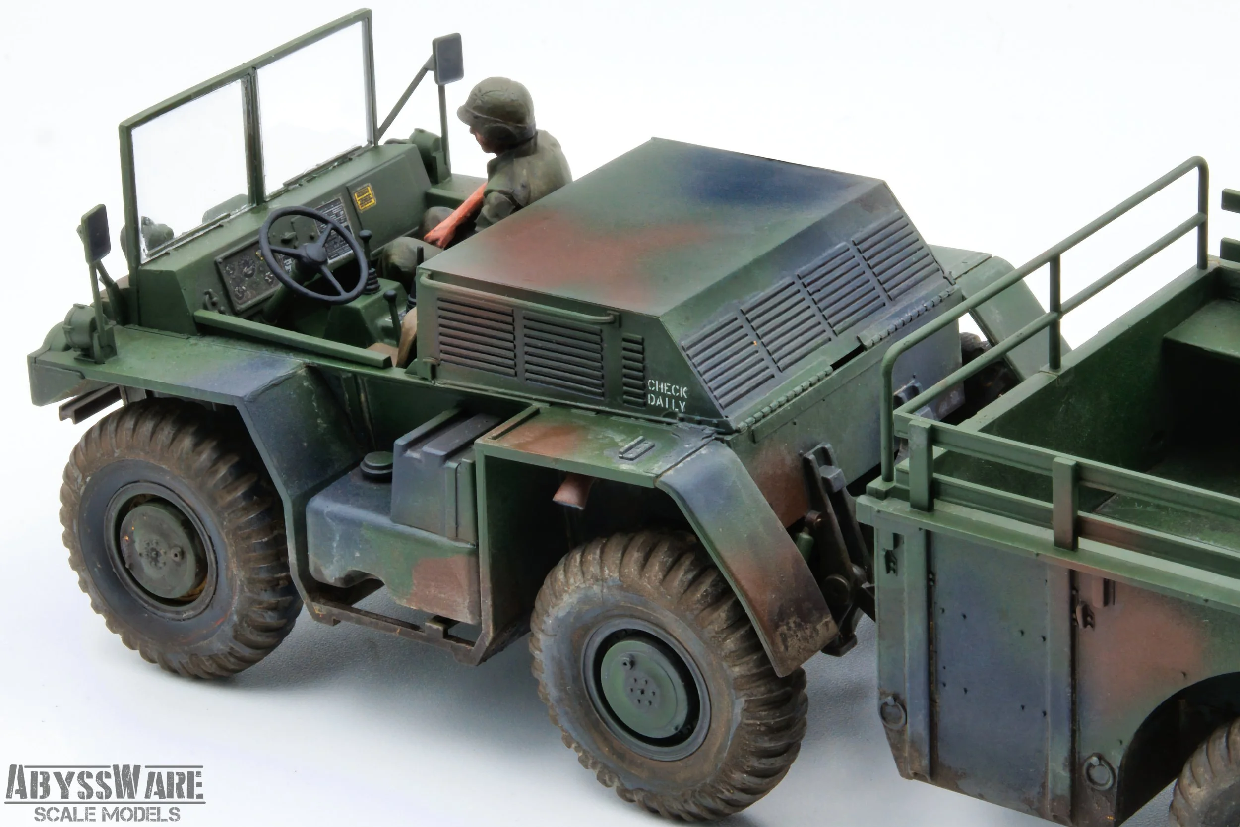 A detailed scale model of a military off-road vehicle with a mounted figure of a soldier in a helmet, green camouflage paint, and rugged tires, built by AbyssWare Scale Models.
