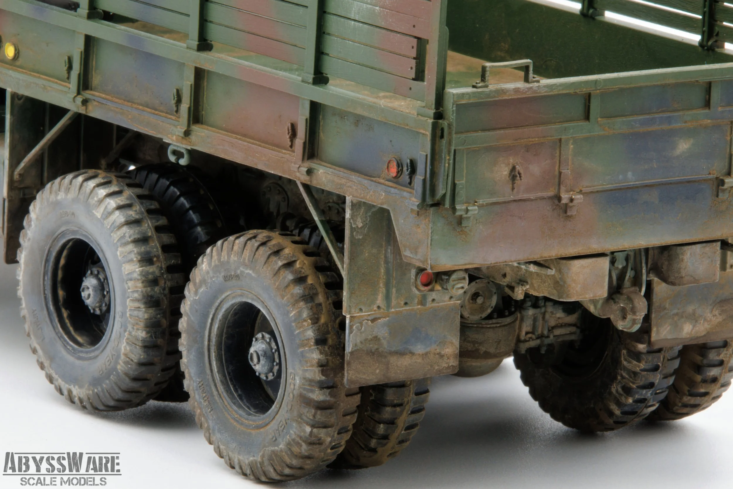 Close-up of a rugged model military truck with muddy tires and weathered green metal body, made by AbyssWare Scale Models.