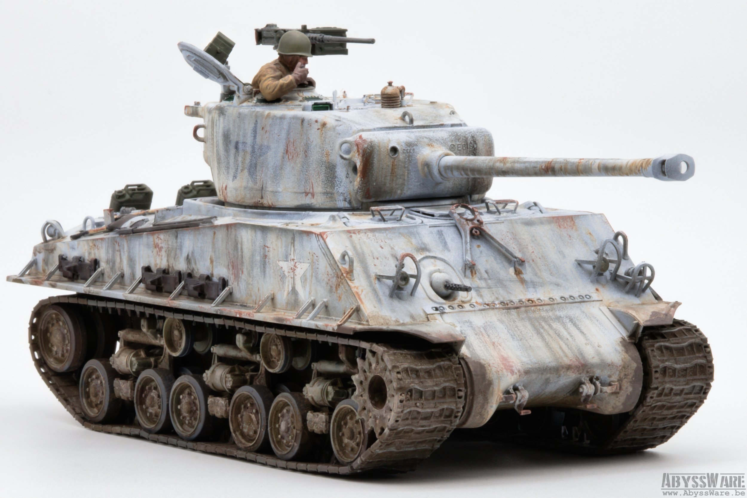 Model of a weathered military tank with a soldier figure peeking out from the hatch, set against a plain white background.
