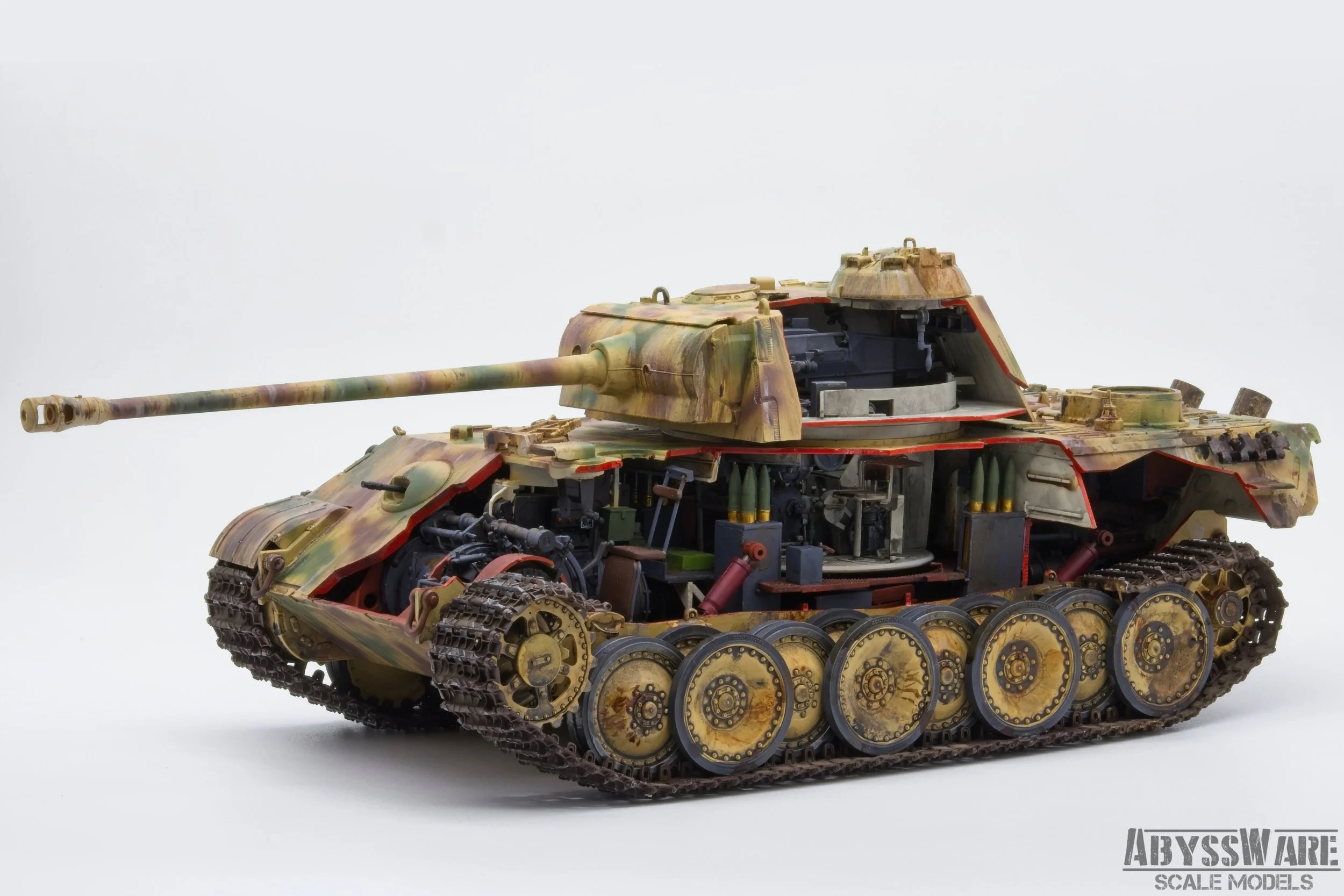 A detailed scale model of a military tank with an open hatch, showing internal components, painted in desert camouflage colors, on a plain white background.