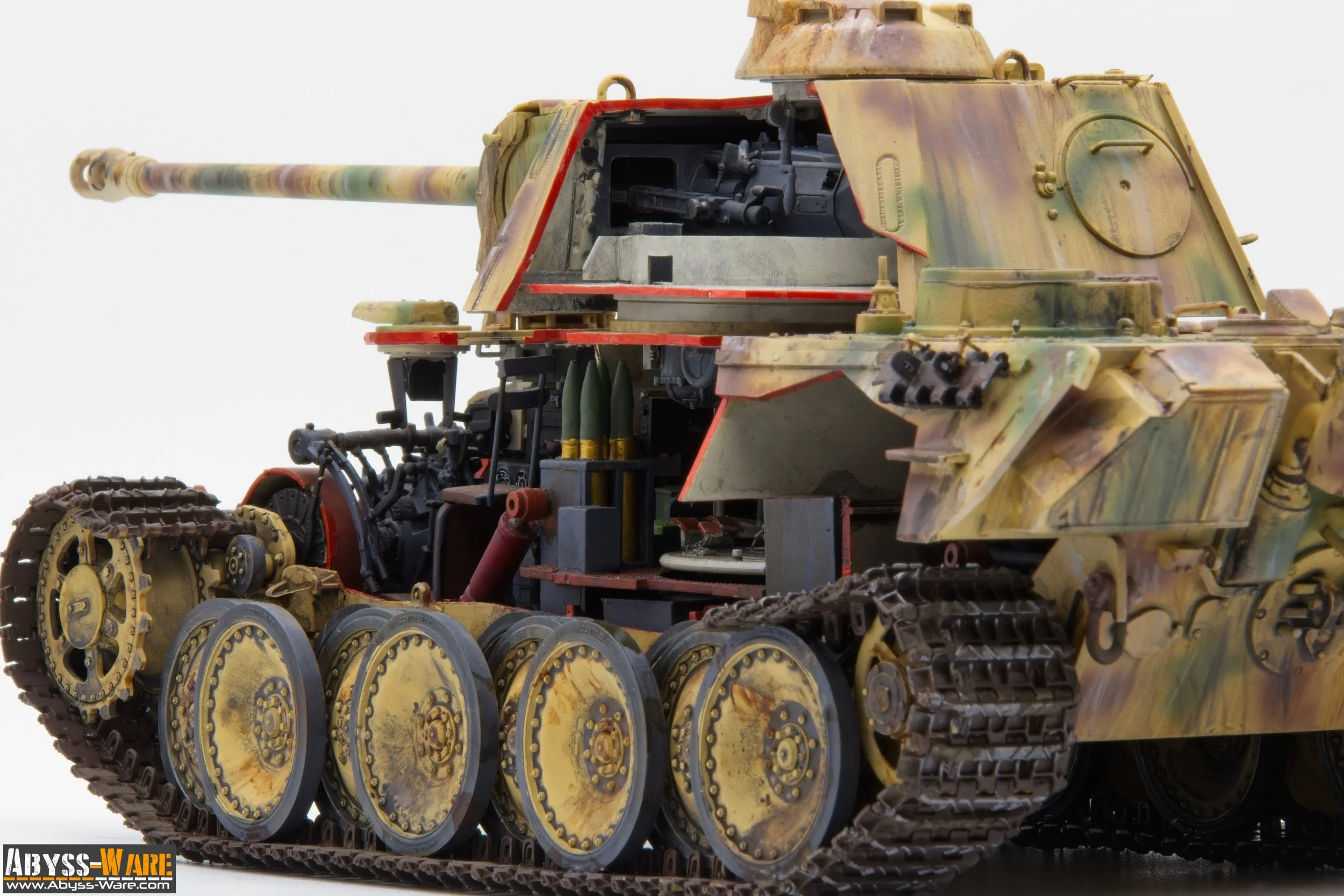 Close-up view of a detailed scale model of a military tank with weathered camouflage paint, showing track wheels, treads, and a mounted gun.