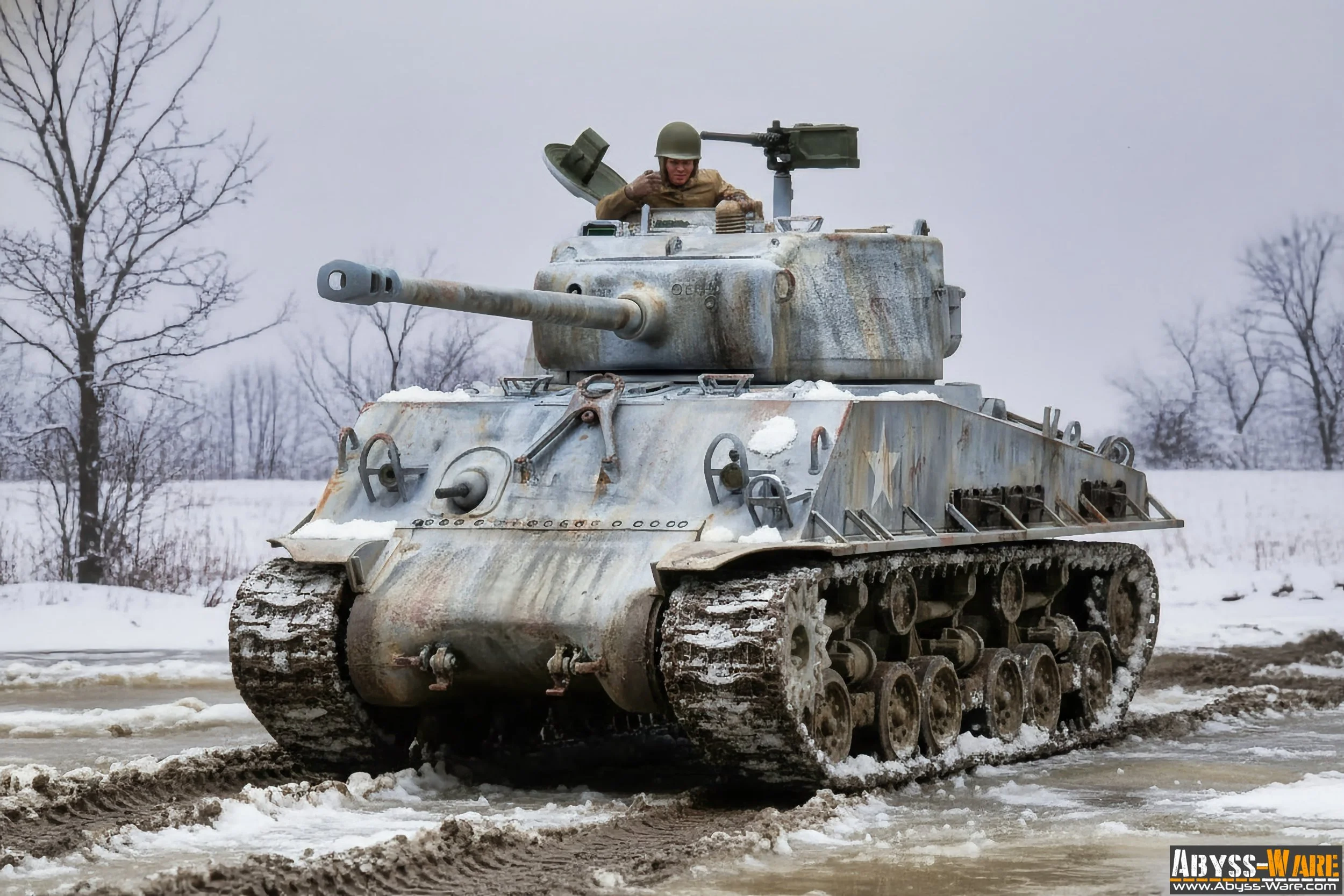 A military tank moving through snowy terrain with a soldier in the turret aiming a mounted machine gun, surrounded by leafless trees under an overcast sky.