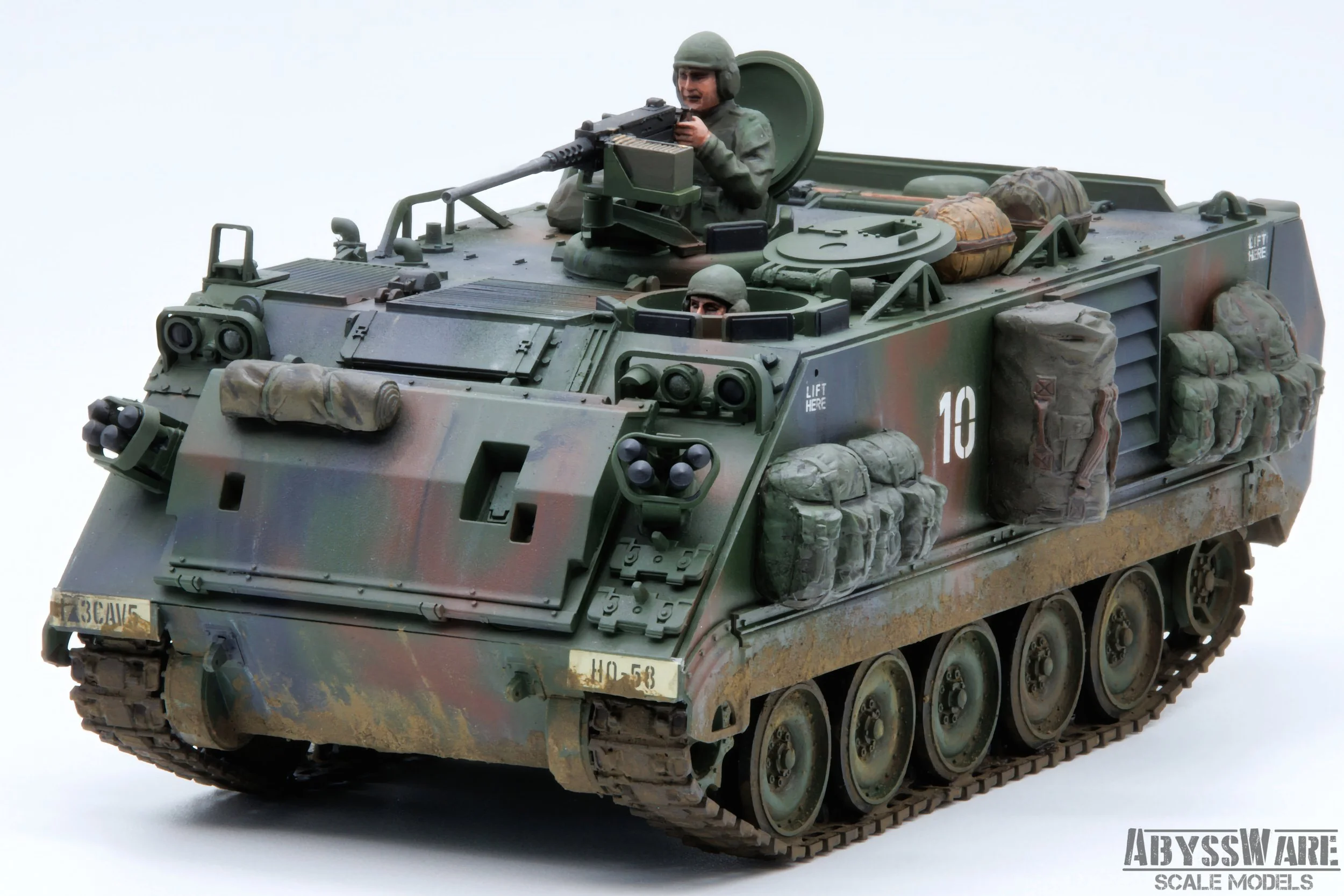 Model military tank with soldiers figurines, camouflage pattern, and detailed accessories on a white background.