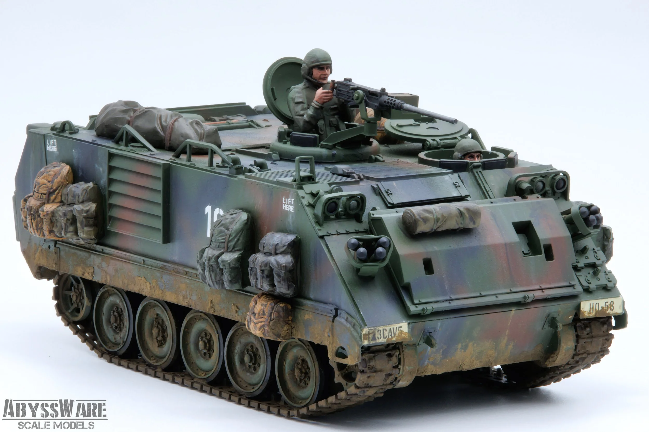 Scale model of a military armored vehicle with soldiers and equipment, painted in camouflage.