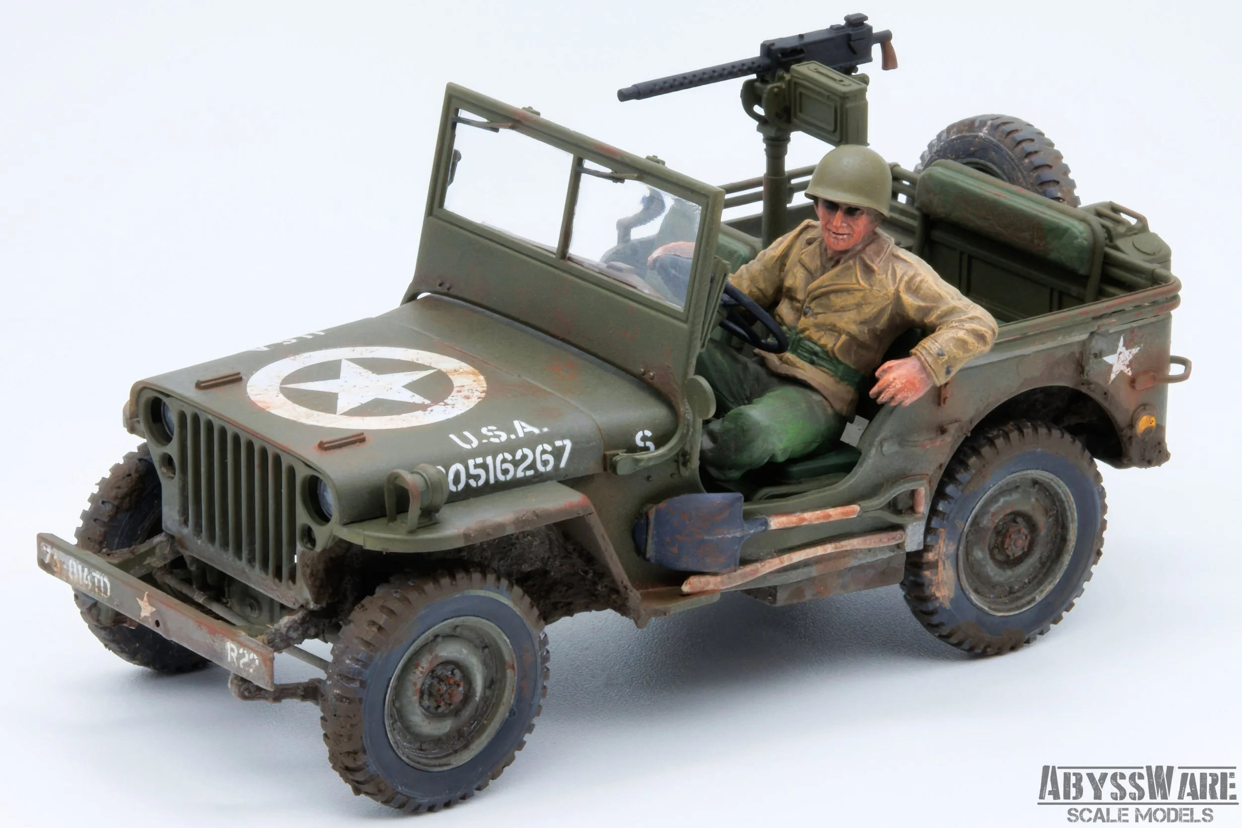 A detailed scale model of a World War II US military jeep with a soldier figure. The jeep has a star emblem on the hood, a mounted machine gun, and weathered, military green paint. The soldier figure is wearing a helmet and military uniform, sitting 