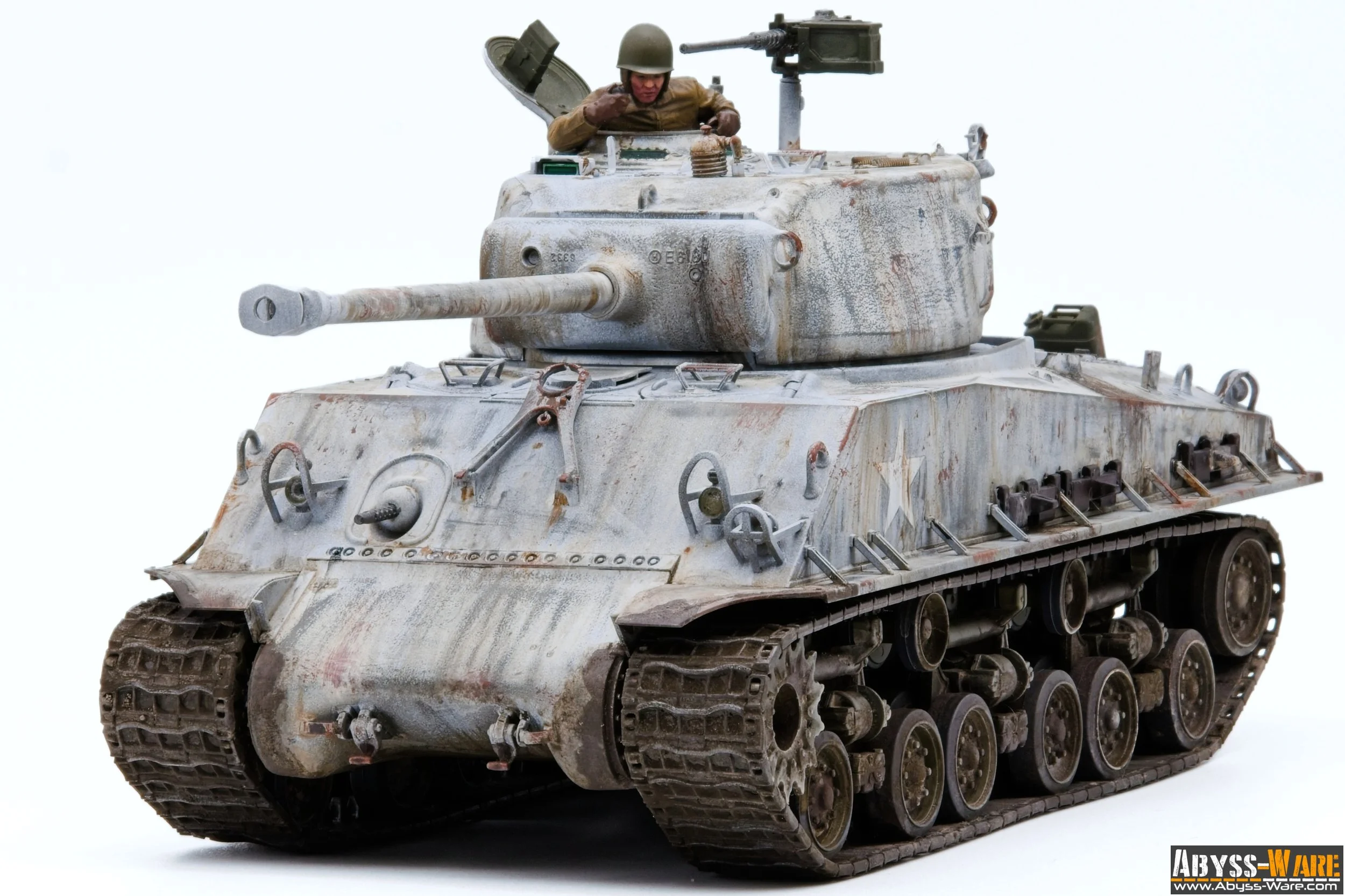 A detailed model of a weathered military tank with a soldier figure inside the turret, equipped with a long barrel cannon and mounted machine gun, against a plain white background.