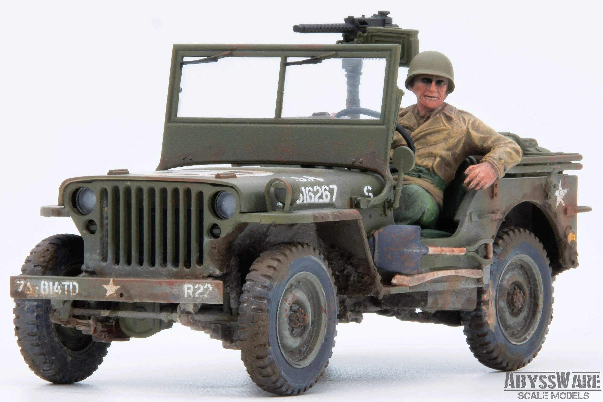 Model military jeep with a soldier figure, wearing a helmet, sitting in the driver’s seat, painted in green camouflage with military markings, against a plain white background.