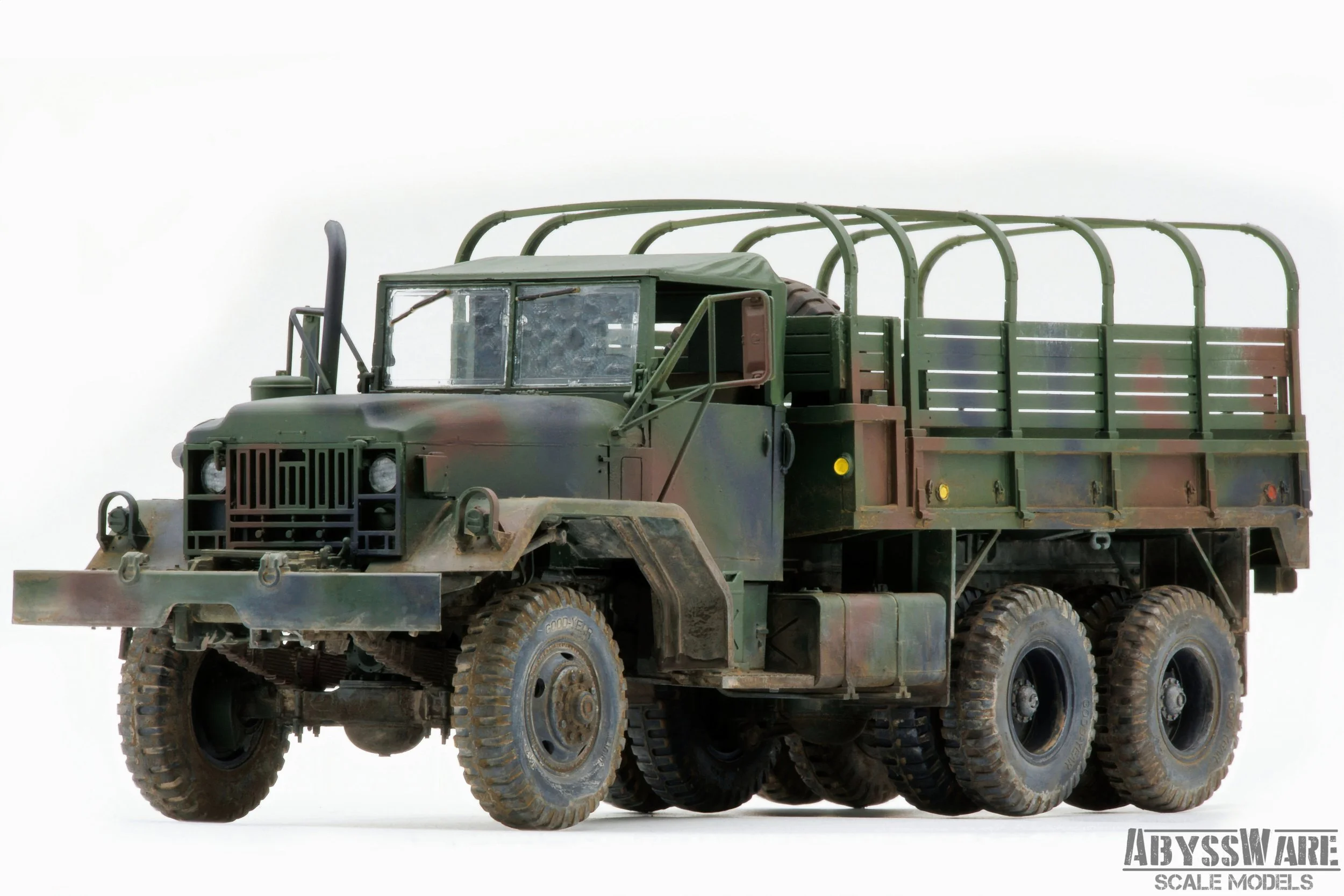 A scale model of a military military truck painted in camouflage colors, with a large open cargo area and rugged tires.
