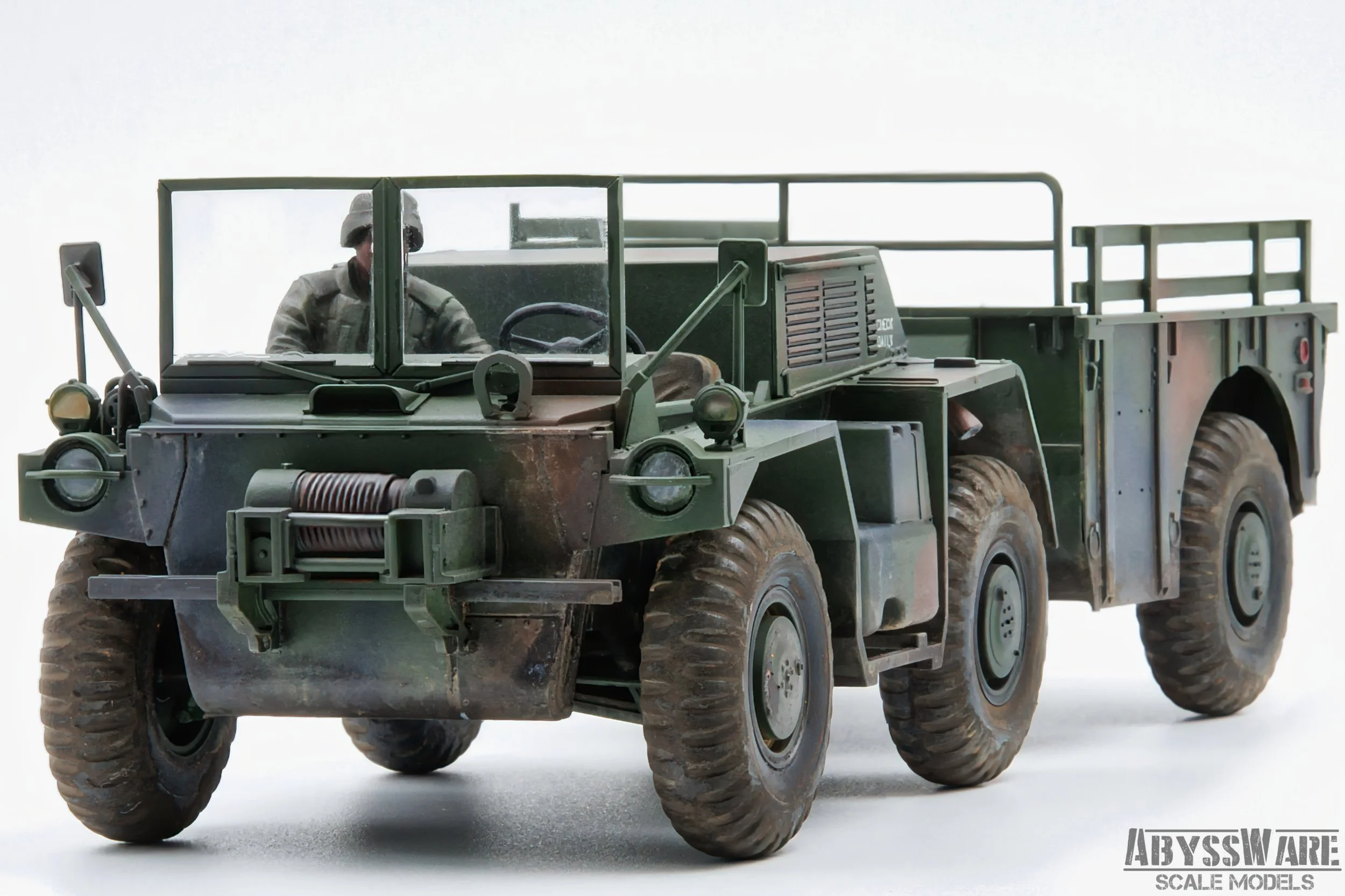A scale model of a green military transport truck with a soldier figure seated at the wheel, photographed against a plain white background.