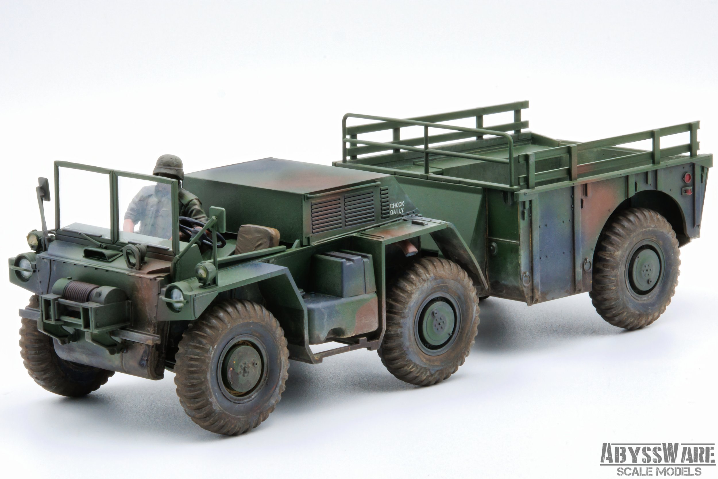 Scale model of a military green cargo truck with a driver figure in the cab, set against a white background.