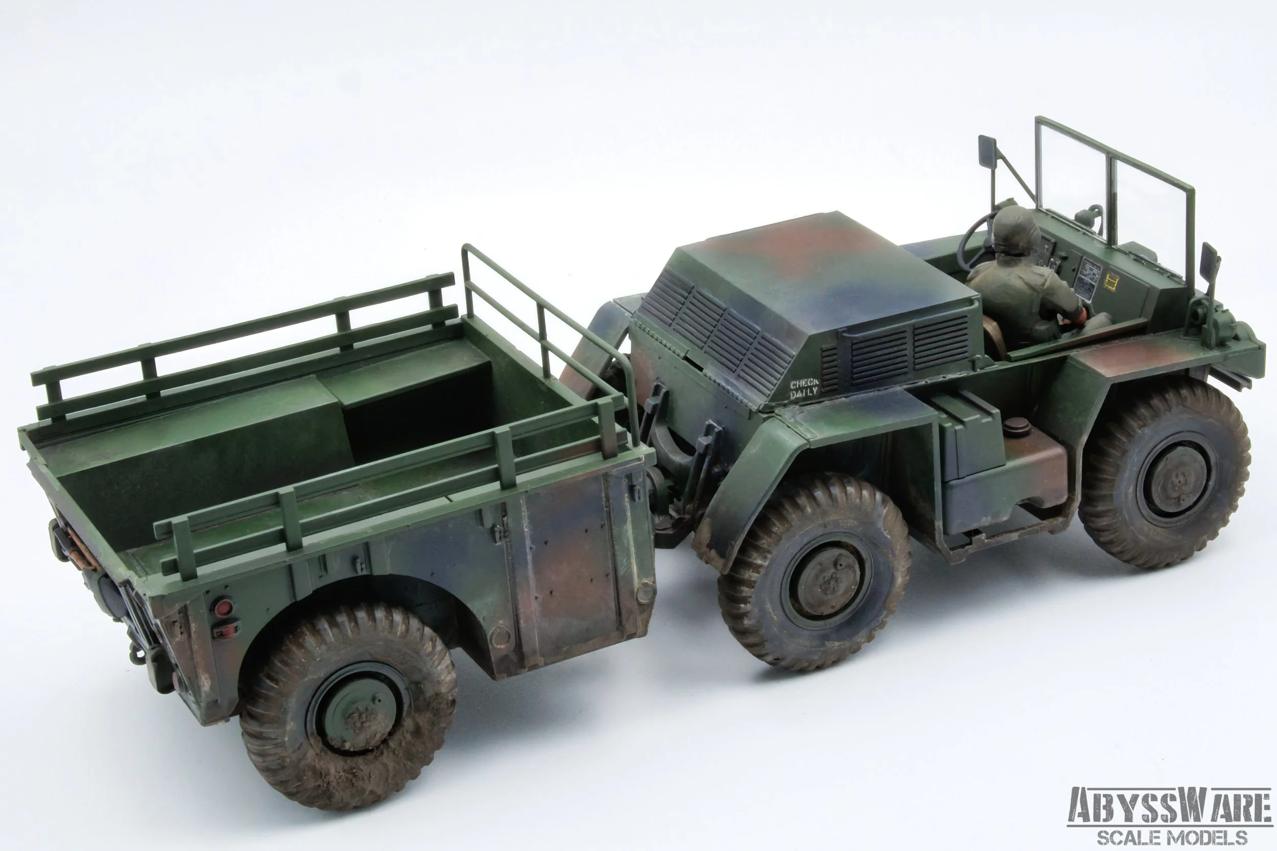 Scale model of a military off-road vehicle with a figure in military uniform driving, painted in camouflage colors, displayed on a white background.