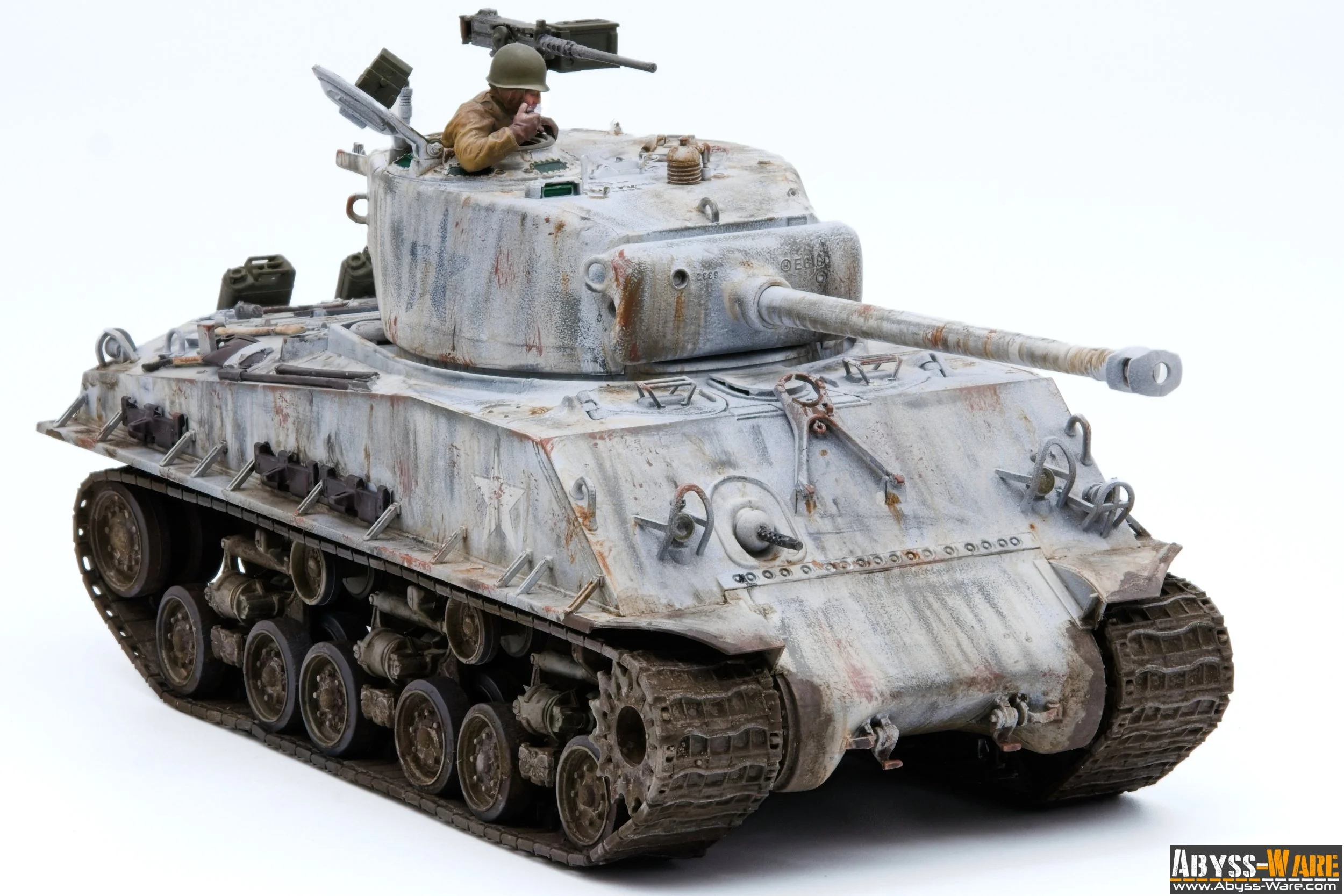Model of a weathered, miniature military tank with a soldier figure in the turret, placed on a white background.