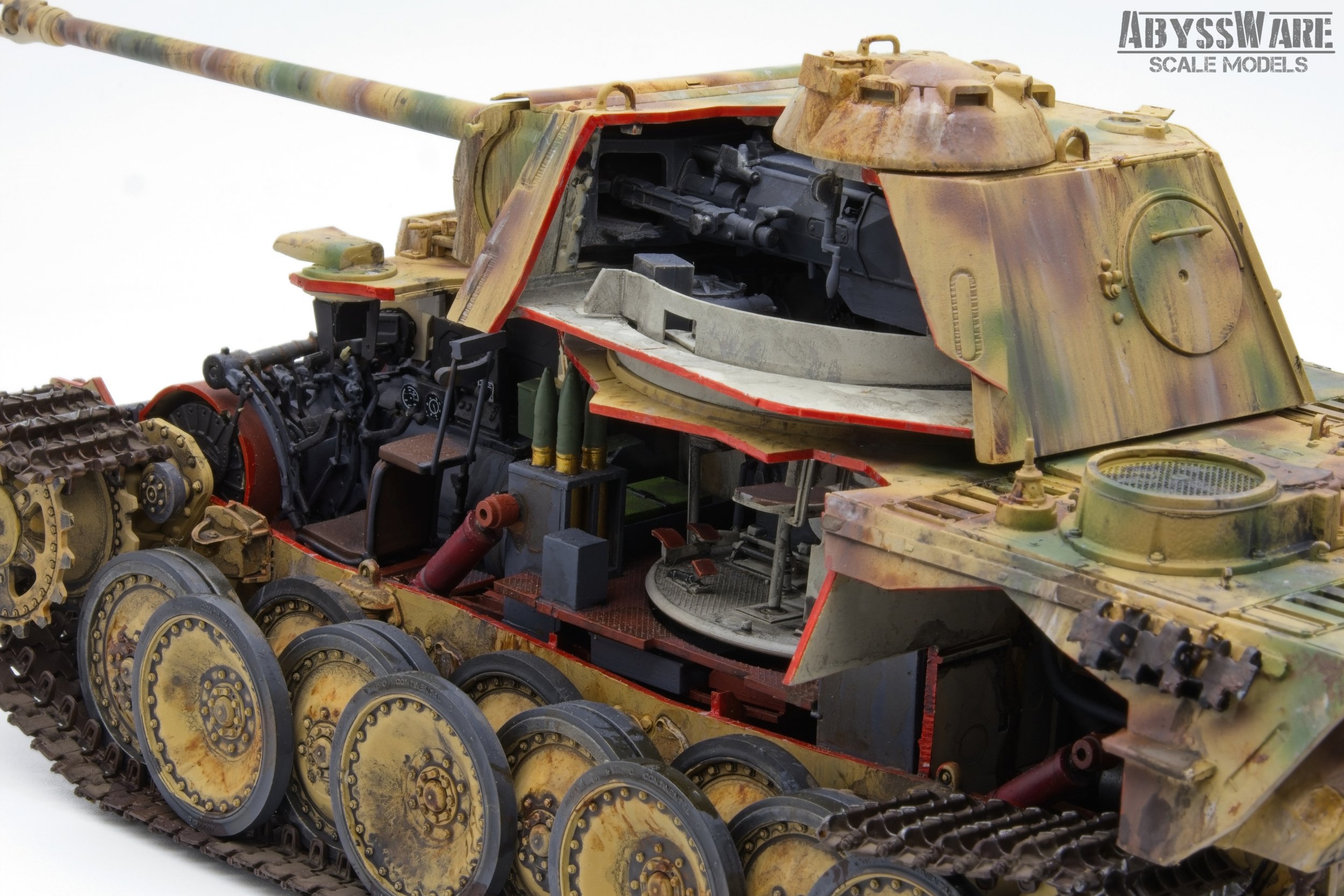 A detailed scale model of a military tank with exposed interior and mechanical components, featuring tracks, wheels, and a camouflage paint job. The tank has an open hatch revealing the interior seating and steering mechanisms.