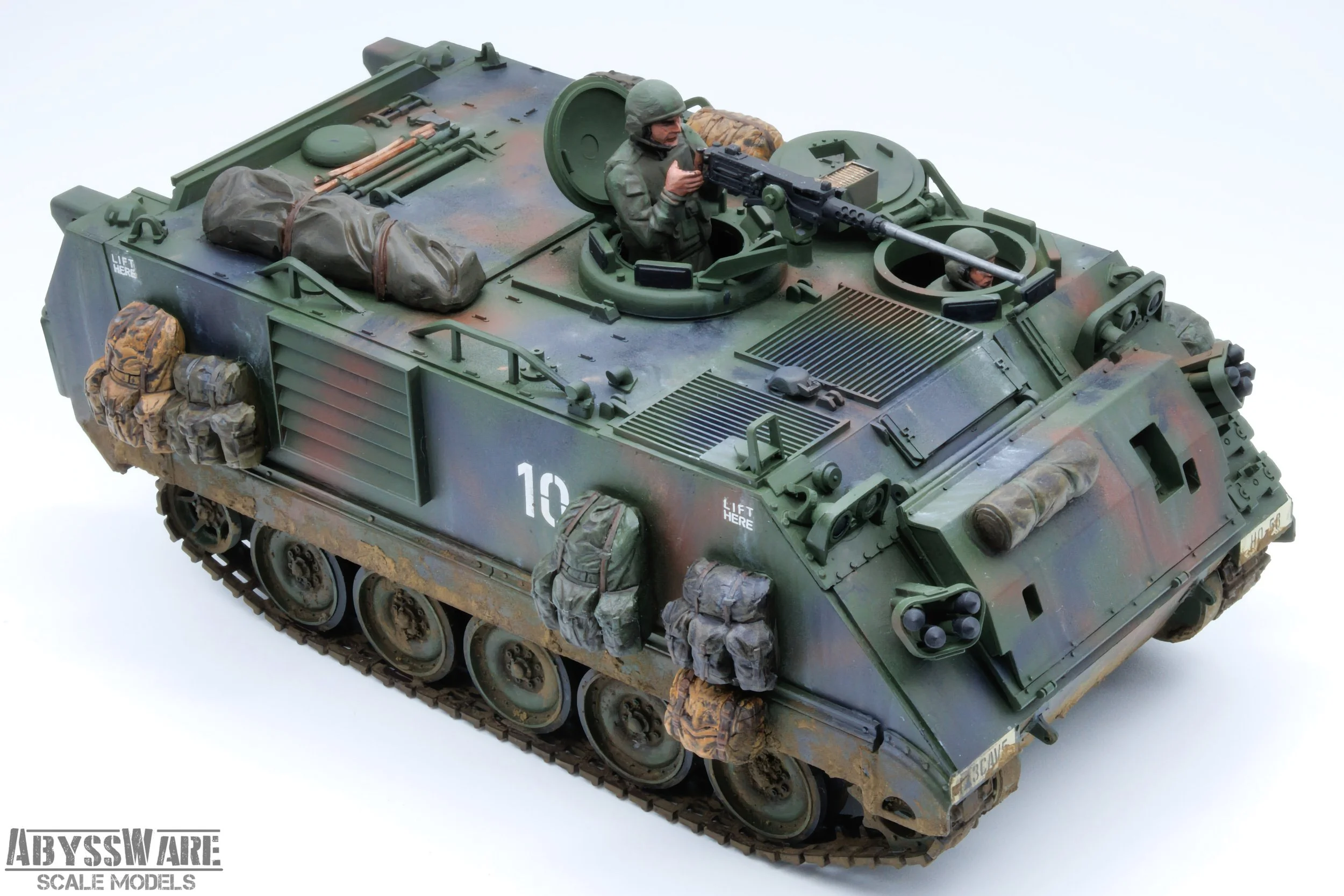 A detailed scale model of a military armored vehicle with a soldier figure on top, holding a machine gun, surrounded by equipment and supplies, on a plain white background.