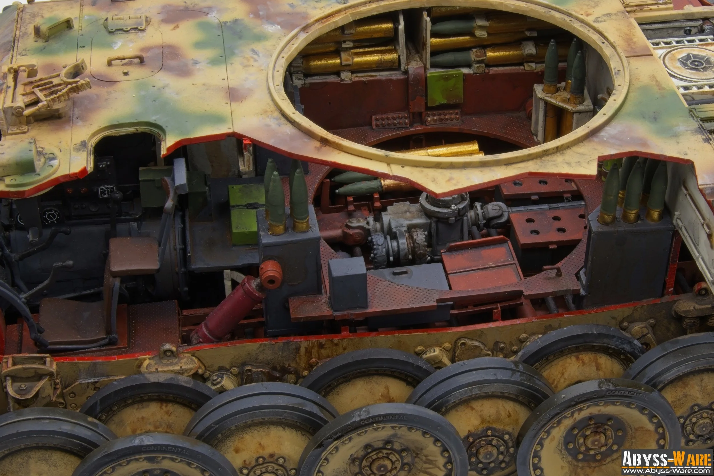 Close-up of a tank's inner mechanical and weaponry components, with some parts painted in camouflage colors and wheels at the bottom, some with rust and dirt.
