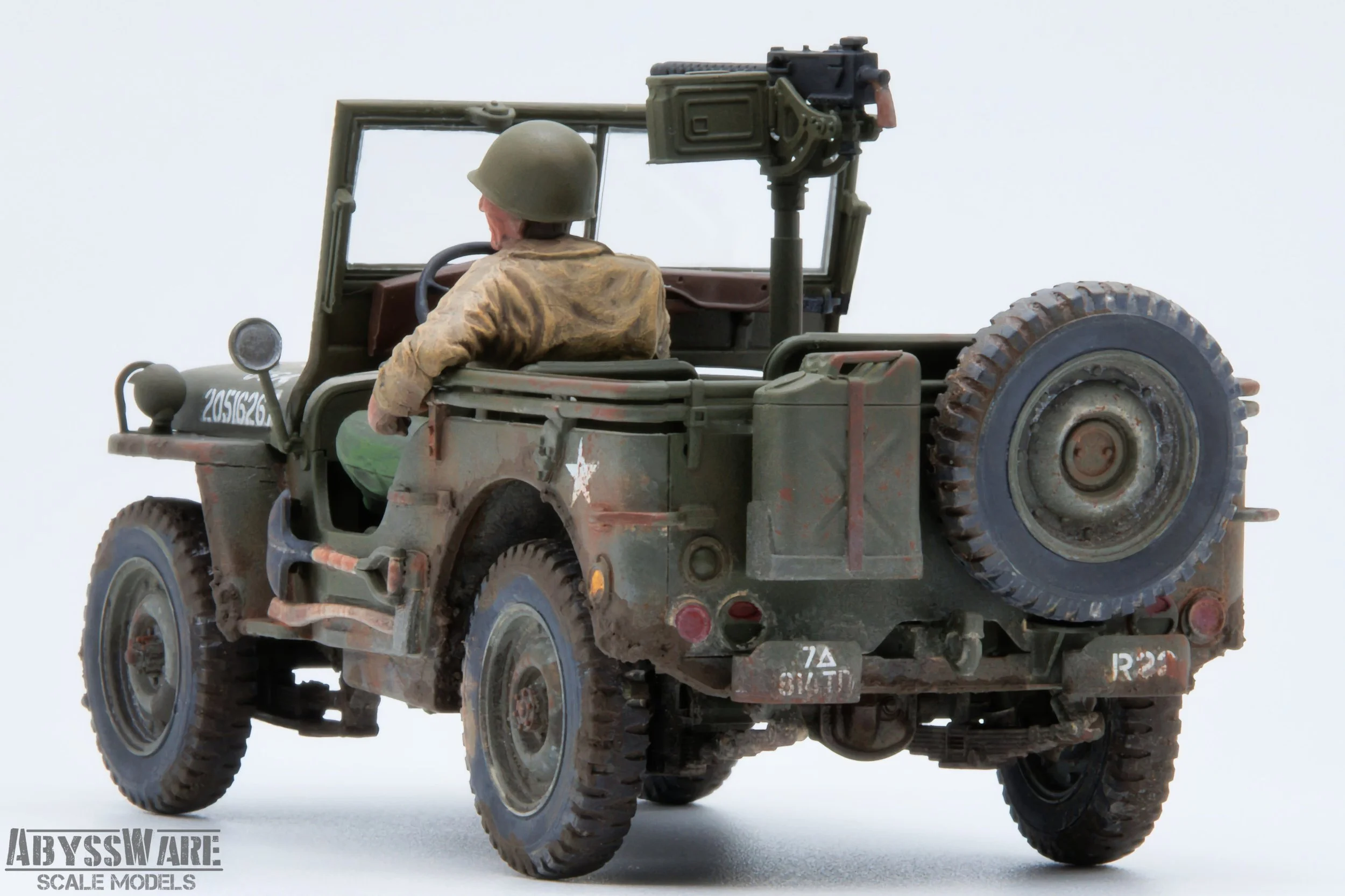 Detailed scale model of a military jeep with a soldier figure driving, featuring weathered paint, a mounted machine gun, and various military markings.