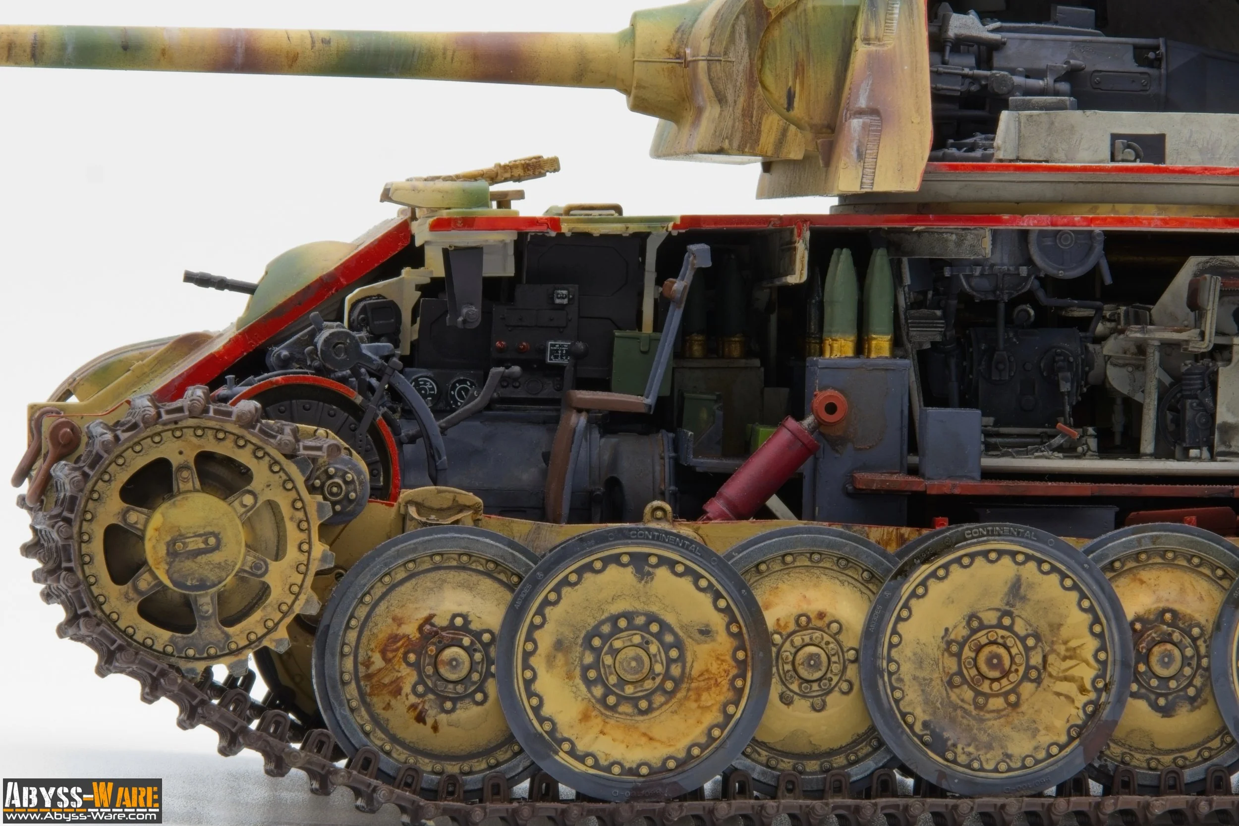 Close-up of a detailed miniature model of a military tank showing the wheels, tracks, and internal components with a white background.