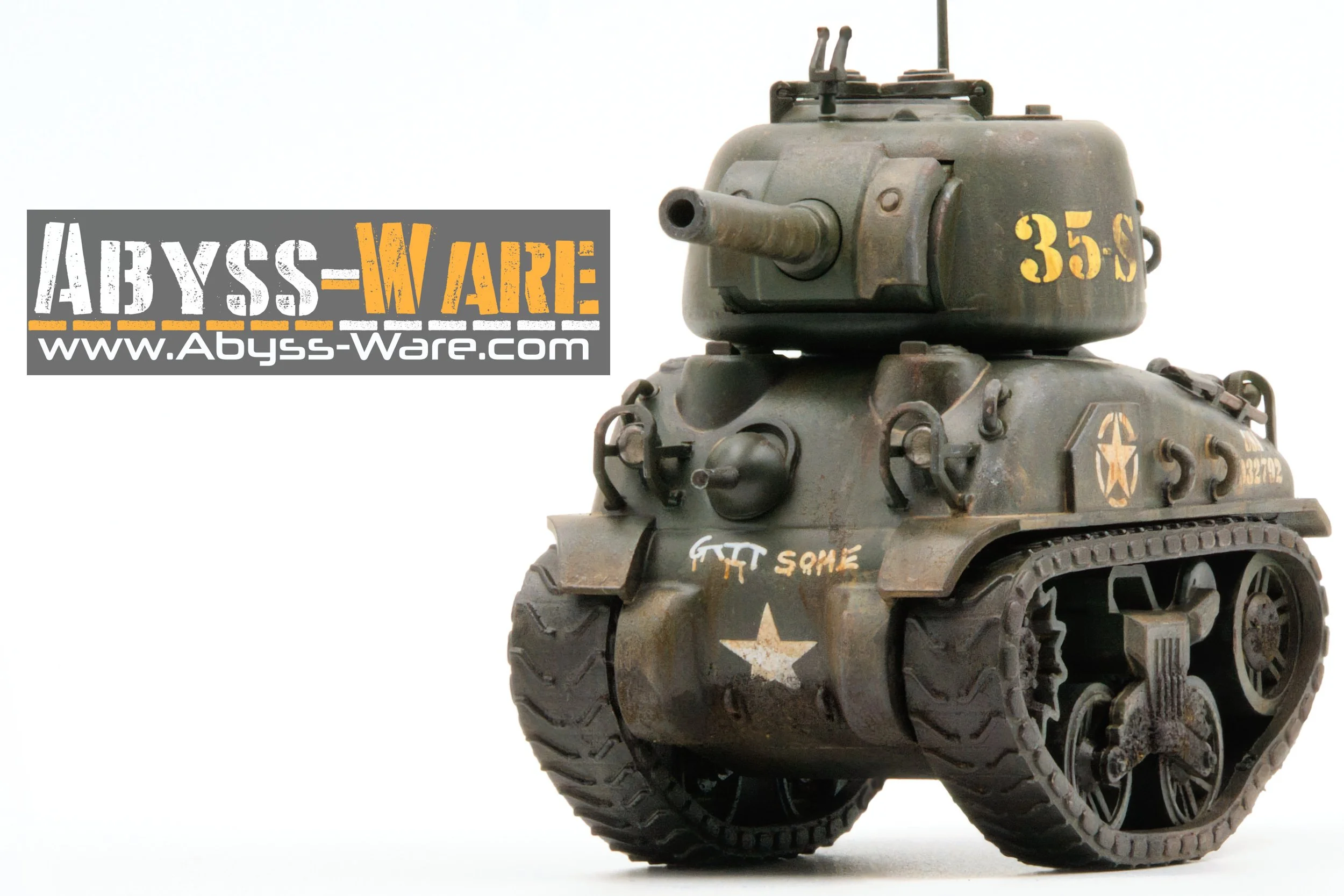 A small model of a military tank with tracks, a turret with a cannon, marked with military symbols and numbers, placed against a white background. The tank has a logo with a star and text reading 'GTT SQUARE' on its front. To the left, there is a lab