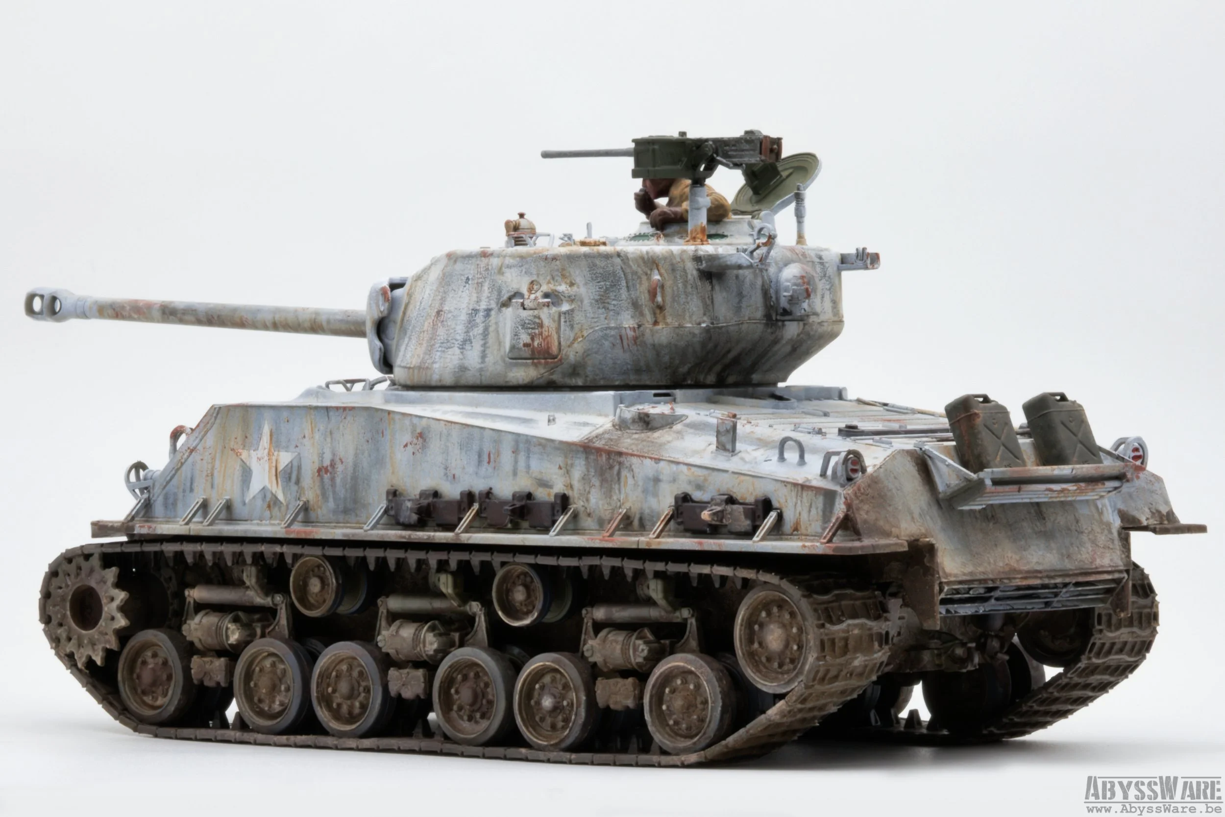 Model of a weathered military tank with a long barrel, camouflage paint, and a mounted machine gun, photographed against a plain white background.