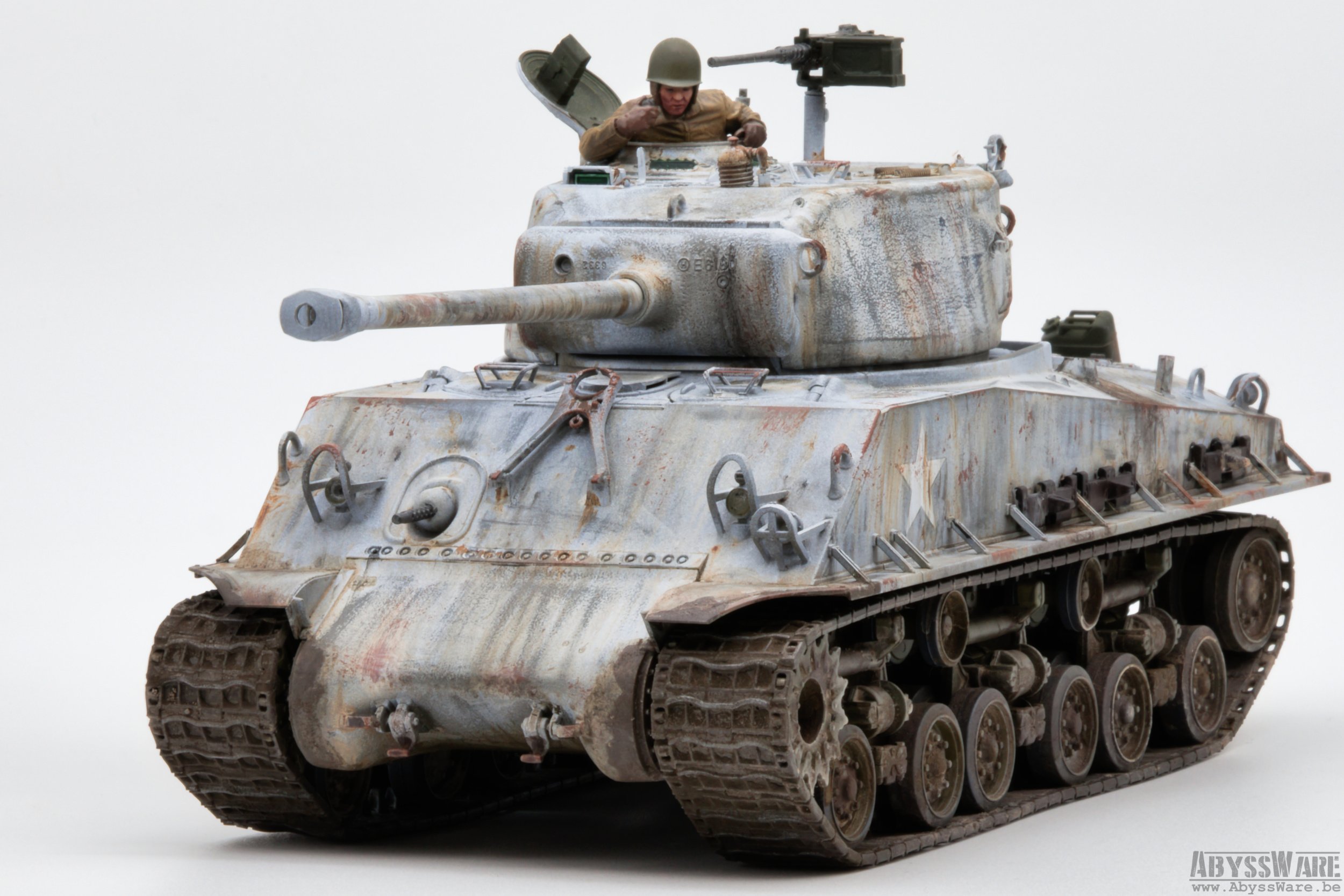A detailed model of a military tank with a weathered, rusted appearance, a soldier figure in the turret, and a white background.