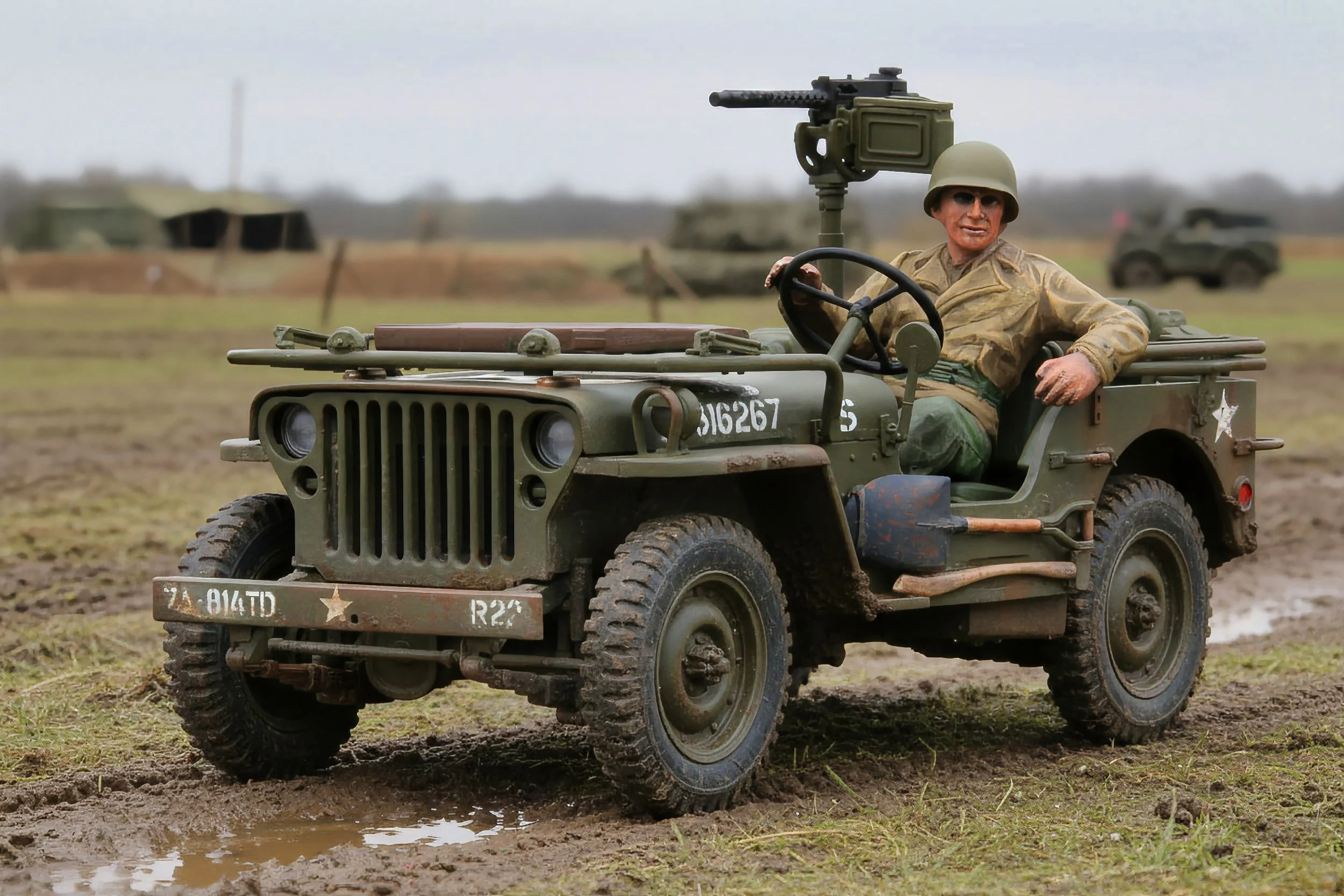 A vintage military jeep with a soldier figure wearing a helmet and sunglasses, equipped with a mounted machine gun, on a muddy field with other military vehicles in the background.
