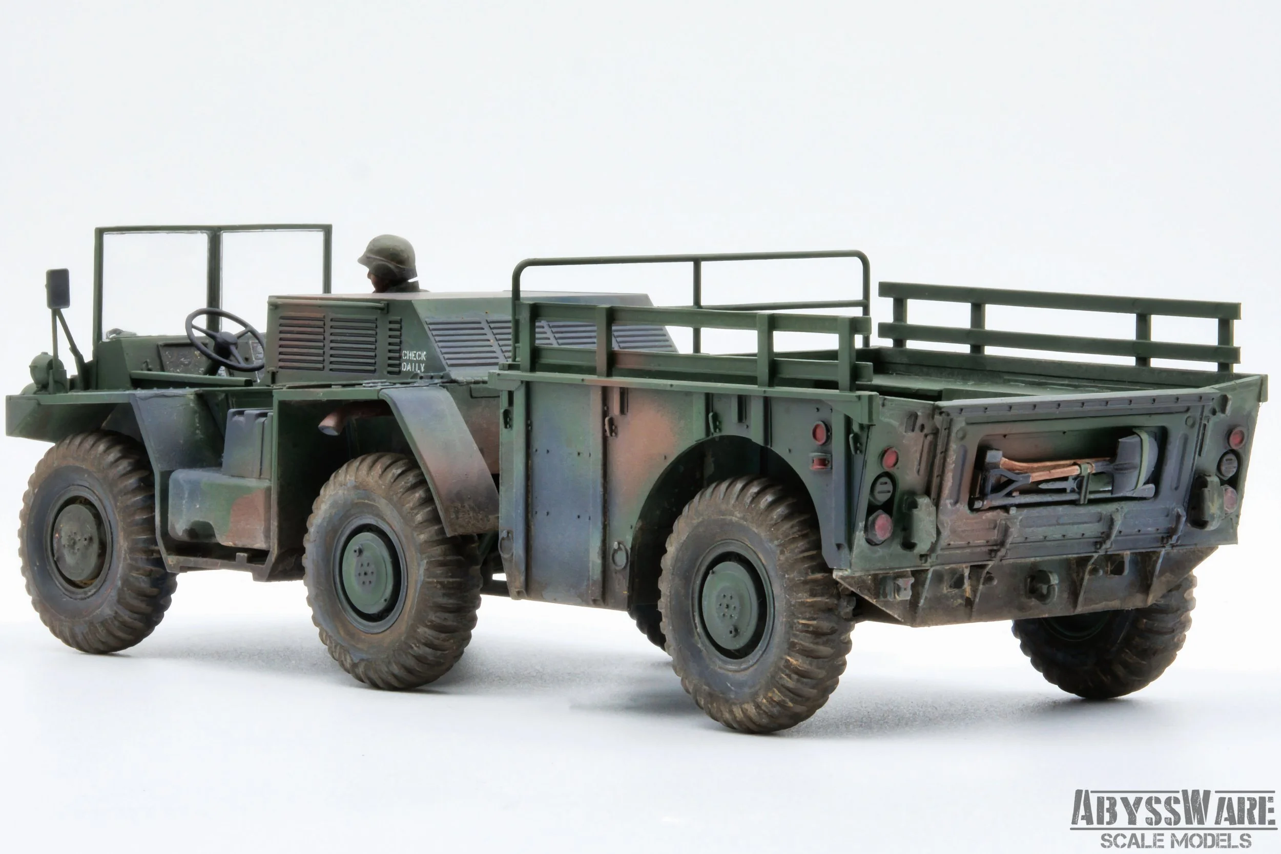Scale model of a military all-terrain vehicle with a green camouflage pattern, featuring a driver figure wearing a helmet, and yardage rails on the back, placed on a plain white background.
