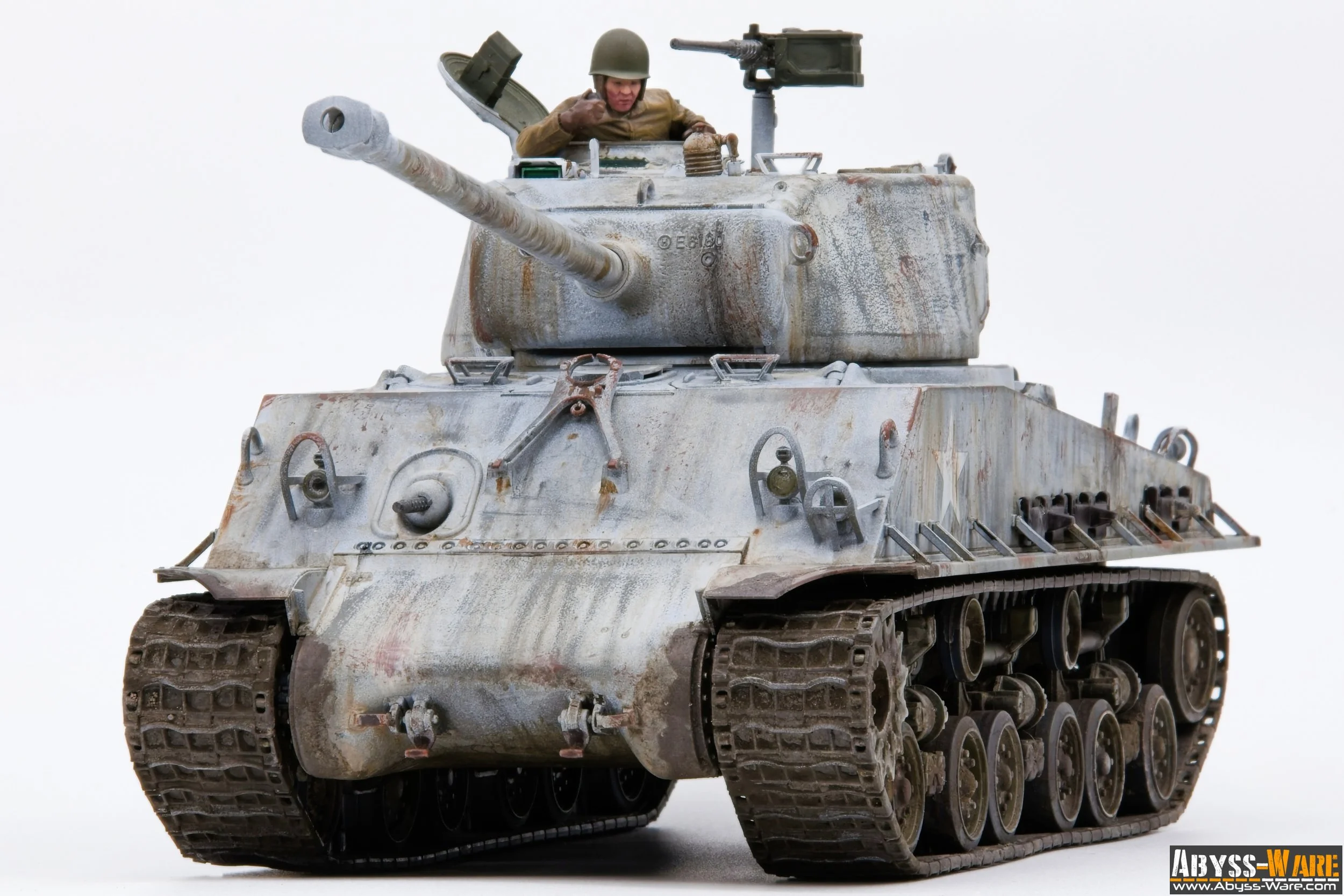 A detailed model of a military tank with a figure of a soldier inside the turret, set against a plain white background.