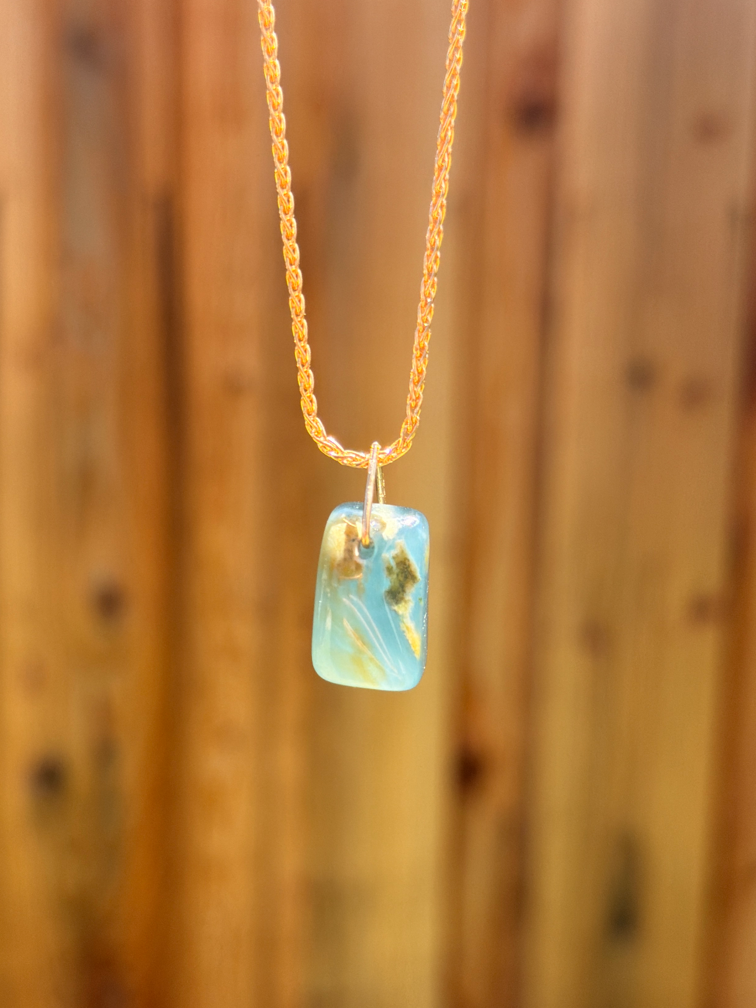 Type A Blue Water Jadeite pendant with natural yellow inclusions, organic freeform translucent jade stone 16mm x 10mm, horizontal slide design on 14k yellow gold filled wheat chain necklace.