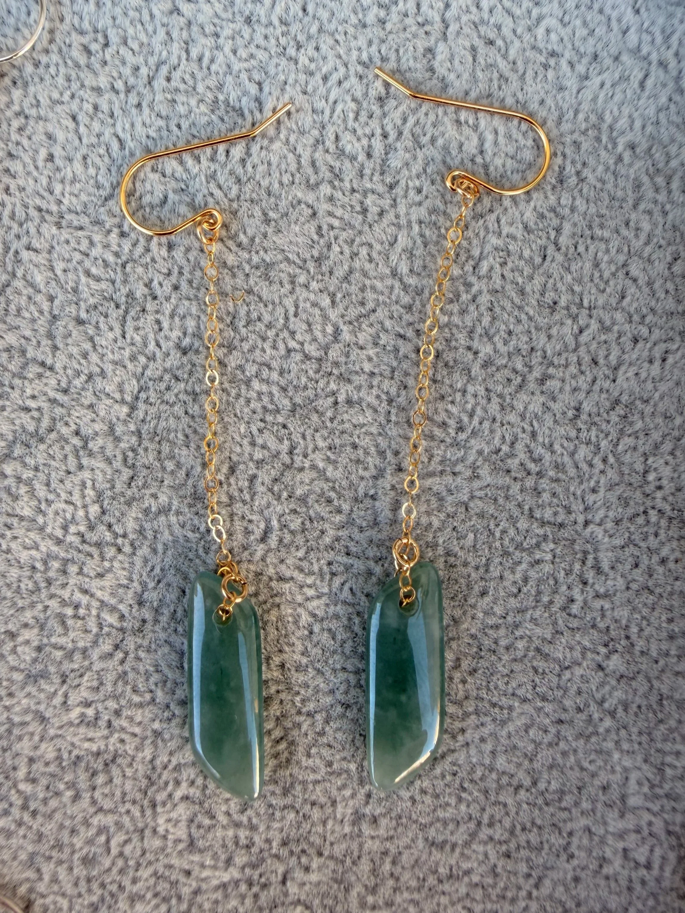 Gold chain dangling earrings with green jadeite jade stones.