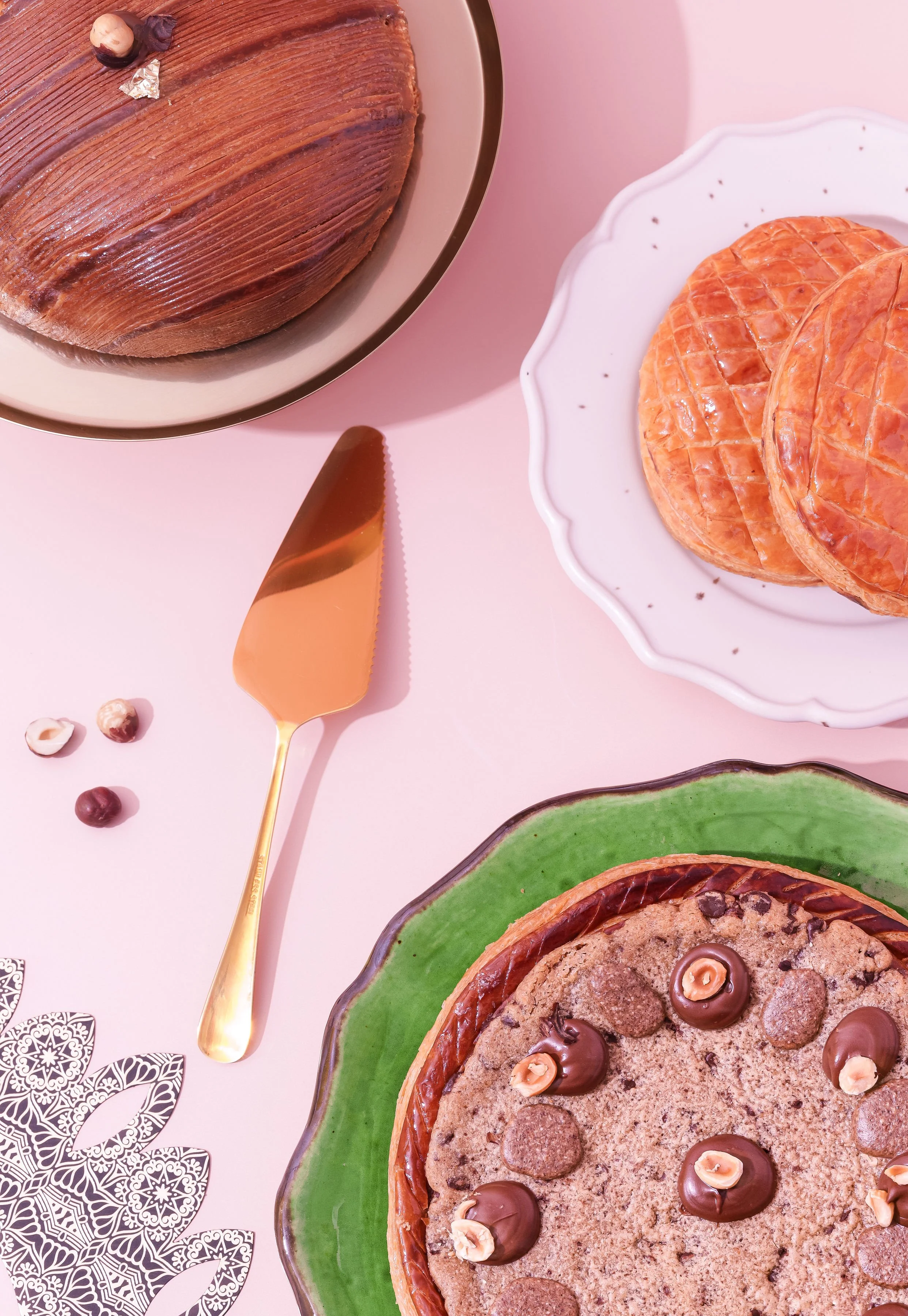 Gâteaux de différentes saveurs sur des assiettes, accompagnés de décorations et d'une fourchette en or