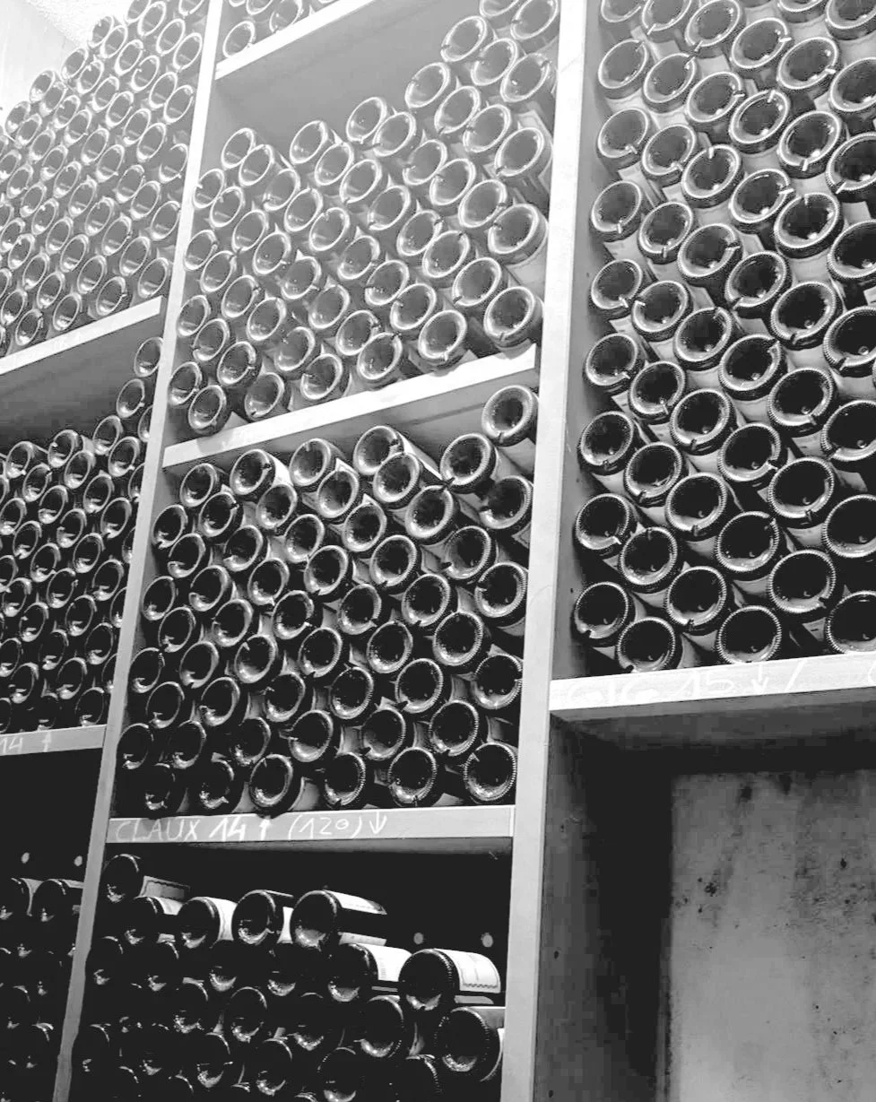 Fût de vin ou de champagne stocké sur des étagères en rangées dans une cave ou une réserve, vue en noir et blanc.