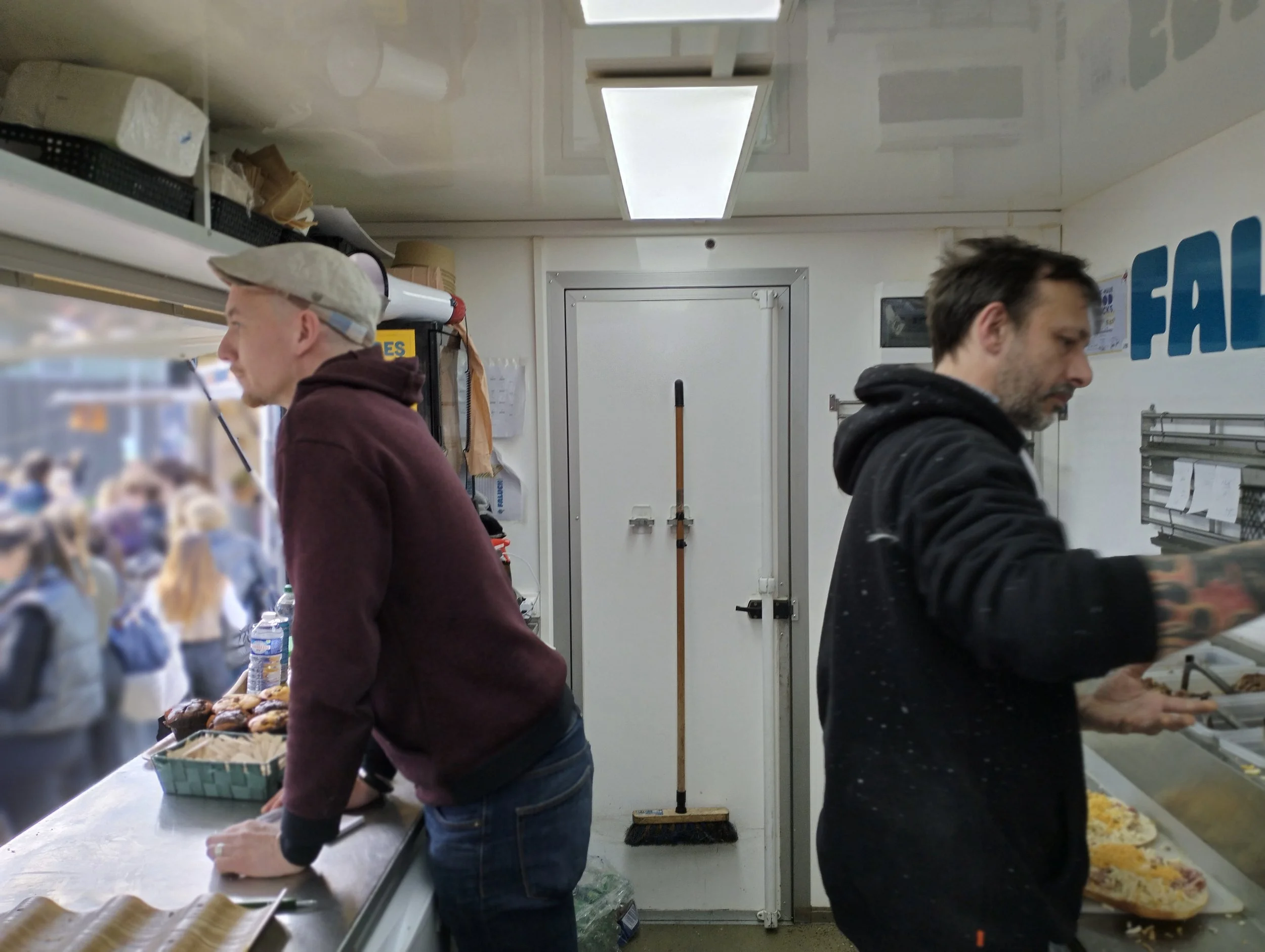 Deux hommes travaillent dans le faluch'truck, dos à dos