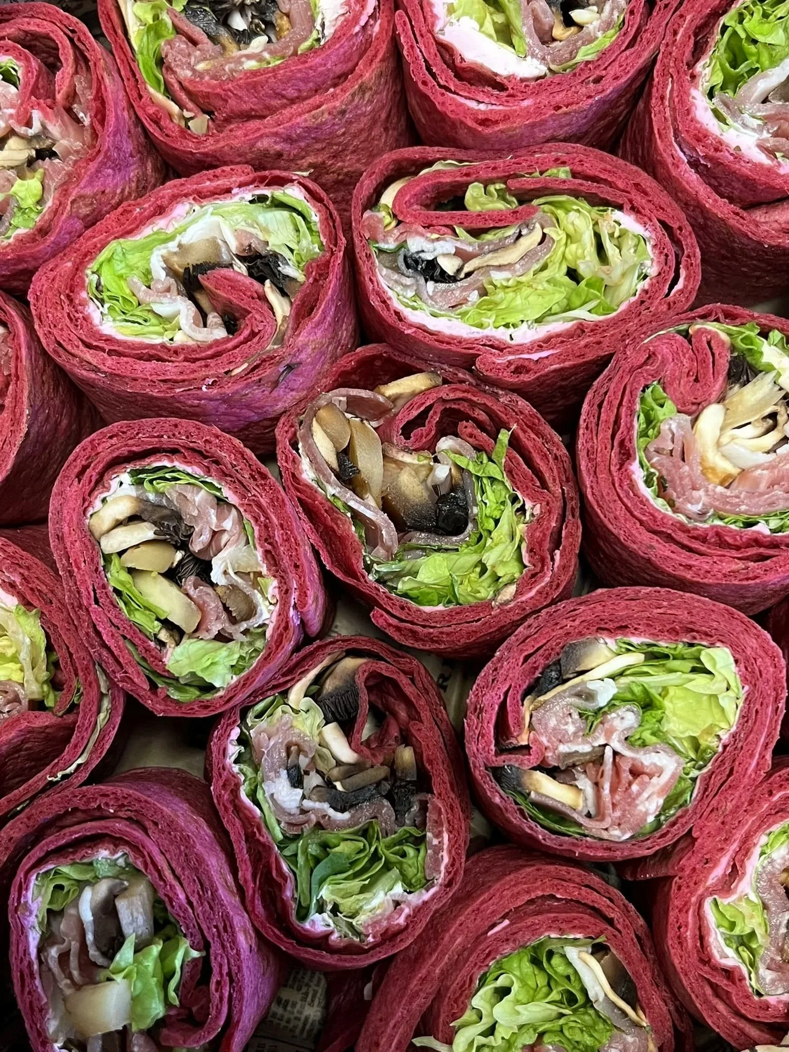 Wraps avec garniture de salade, champignons et autres légumes, couleurs vives, présentation alimentaire.