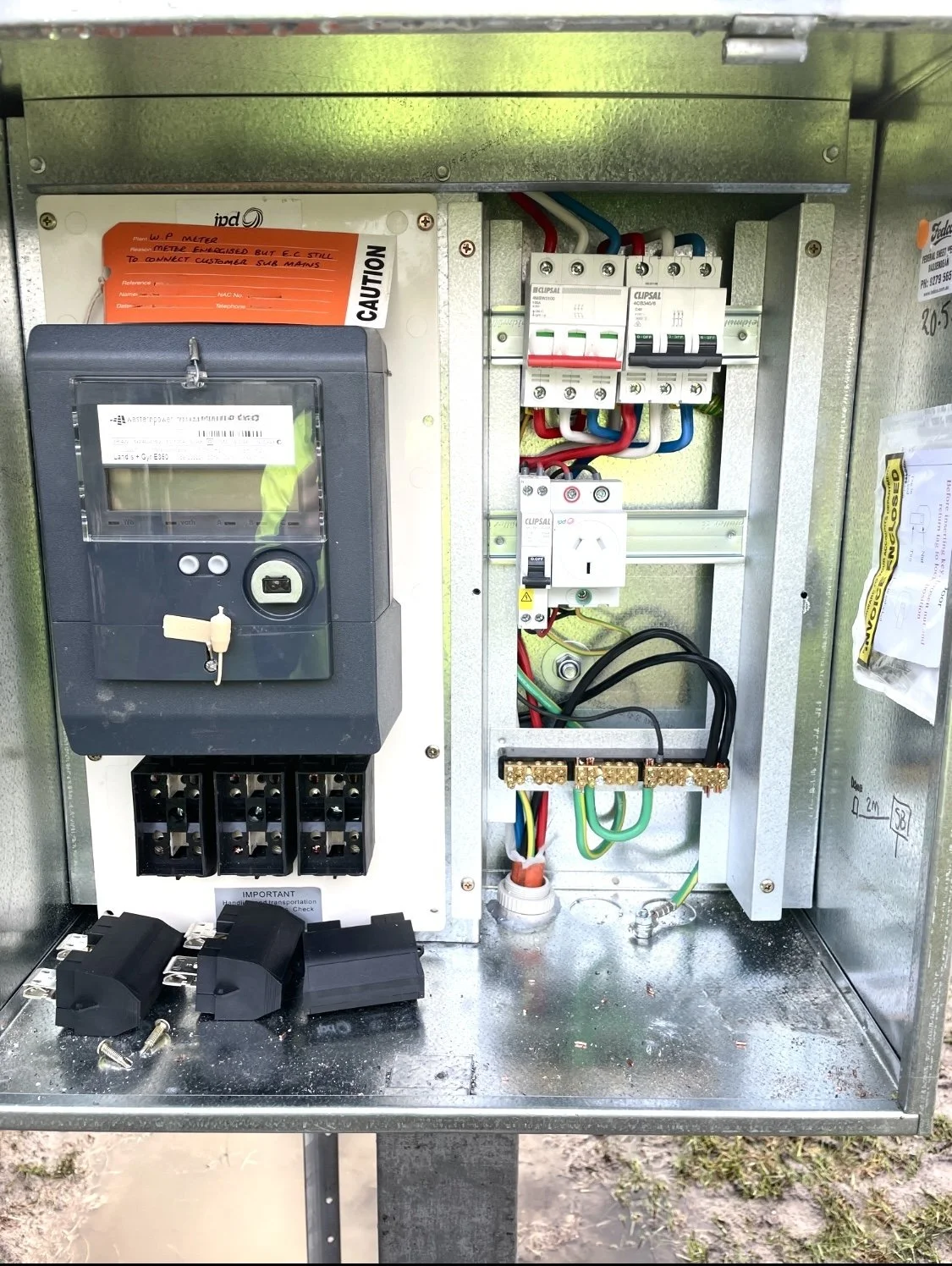 Electrical control box with a digital meter, circuit breakers, and wiring inside.