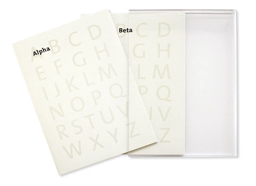  The two volumes “Alpha” and “Beta” with a printed jacket in a plexiglass slipcase. 