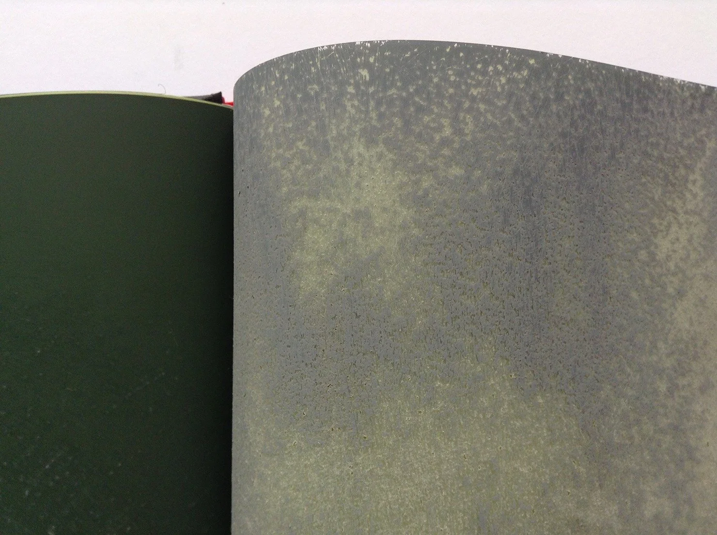  Close up of a page, made of hand sanded silicon carbide microfinsihing film that let the underlying page’s light yellow colour shine through the erasures. 