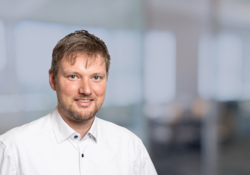 Porträt von Sebastian Dilger, Geschäftsführer Digitalwandler, in einem weißen Hemd in einem modernen Büro.