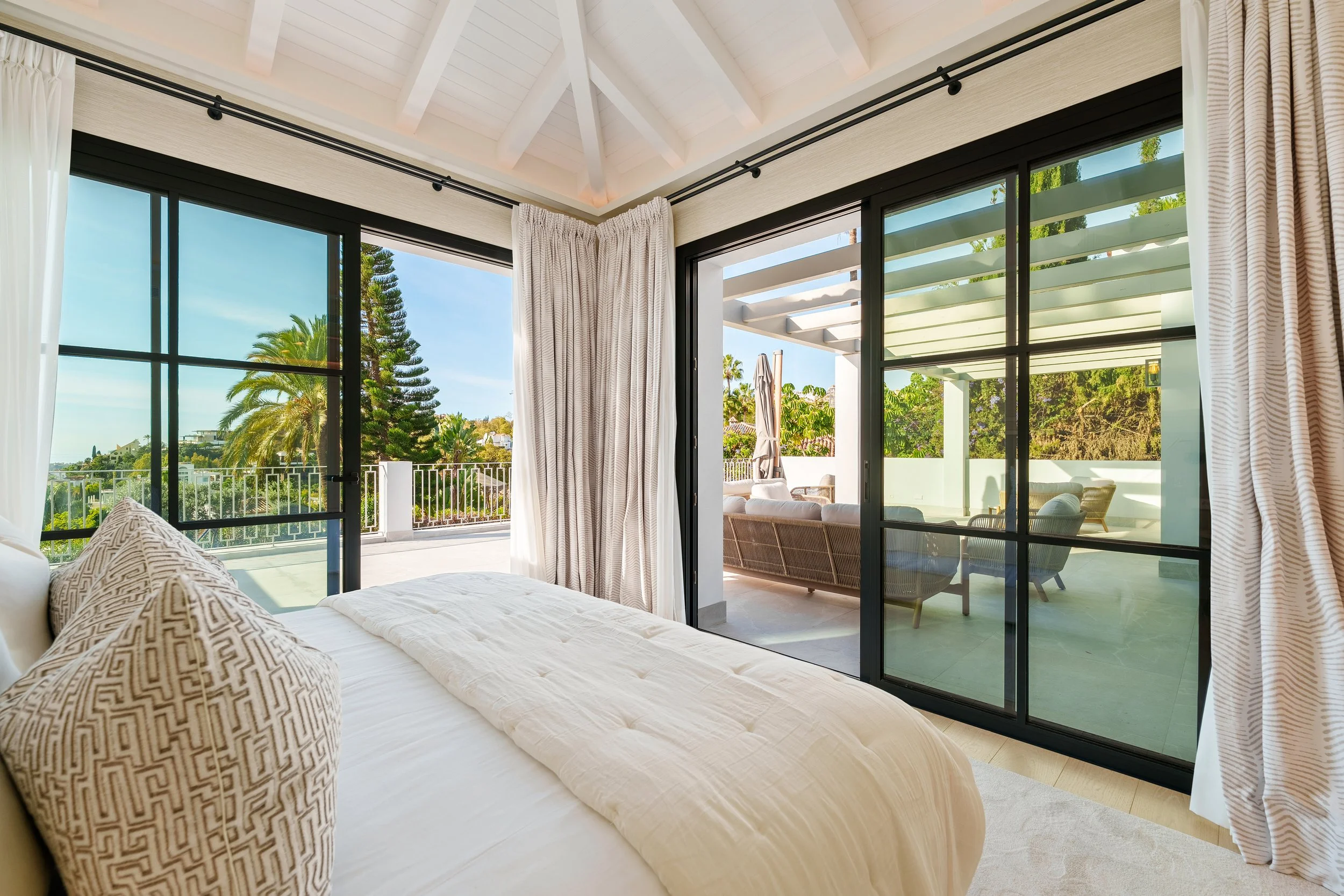 Master Bedroom: The primary retreat featuring vaulted ceilings, a neutral palette, and private terrace access with mountain views.