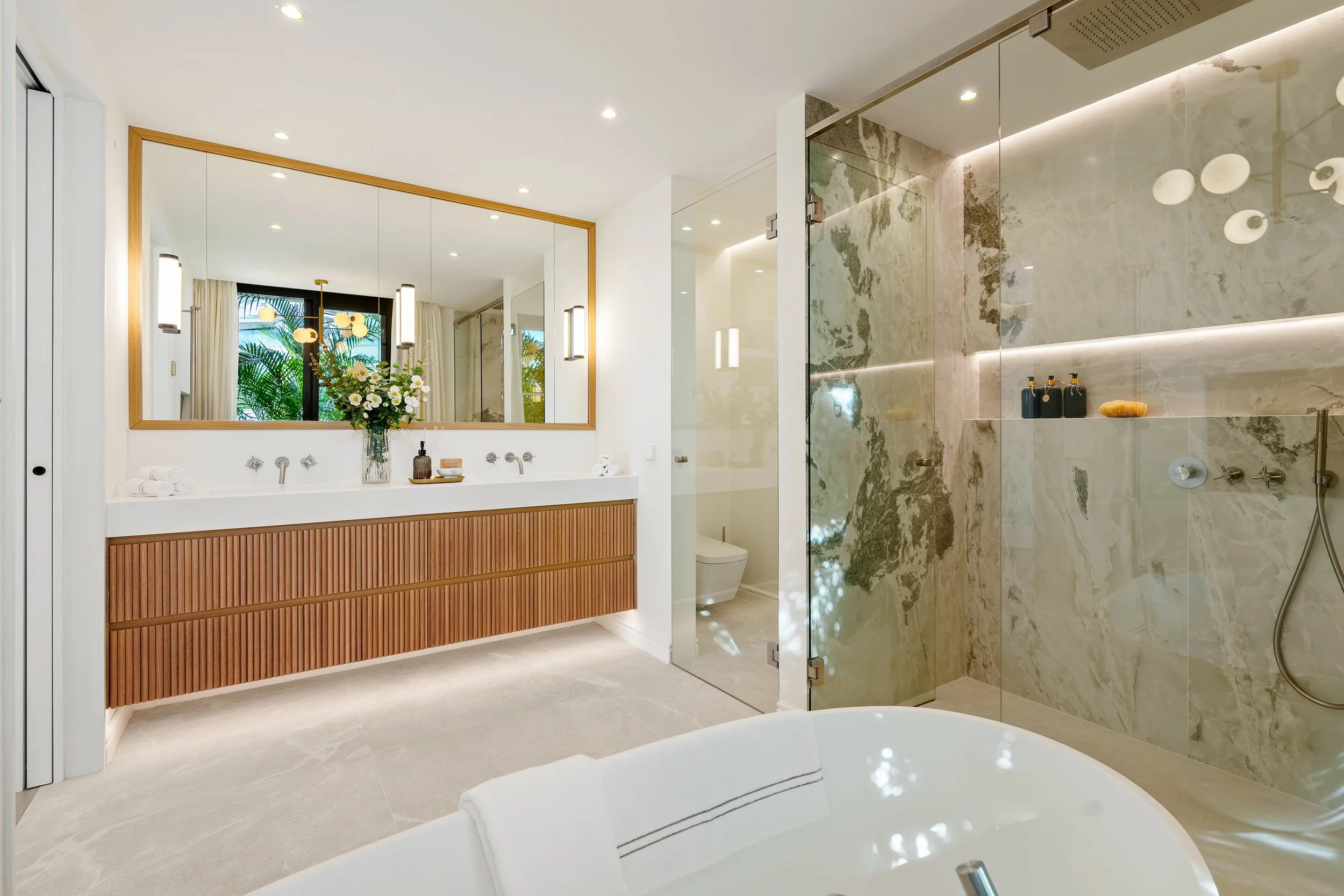Luxury Ensuite: A spa-like bathroom with a freestanding tub, stone-clad walk-in shower, and twin vanities.