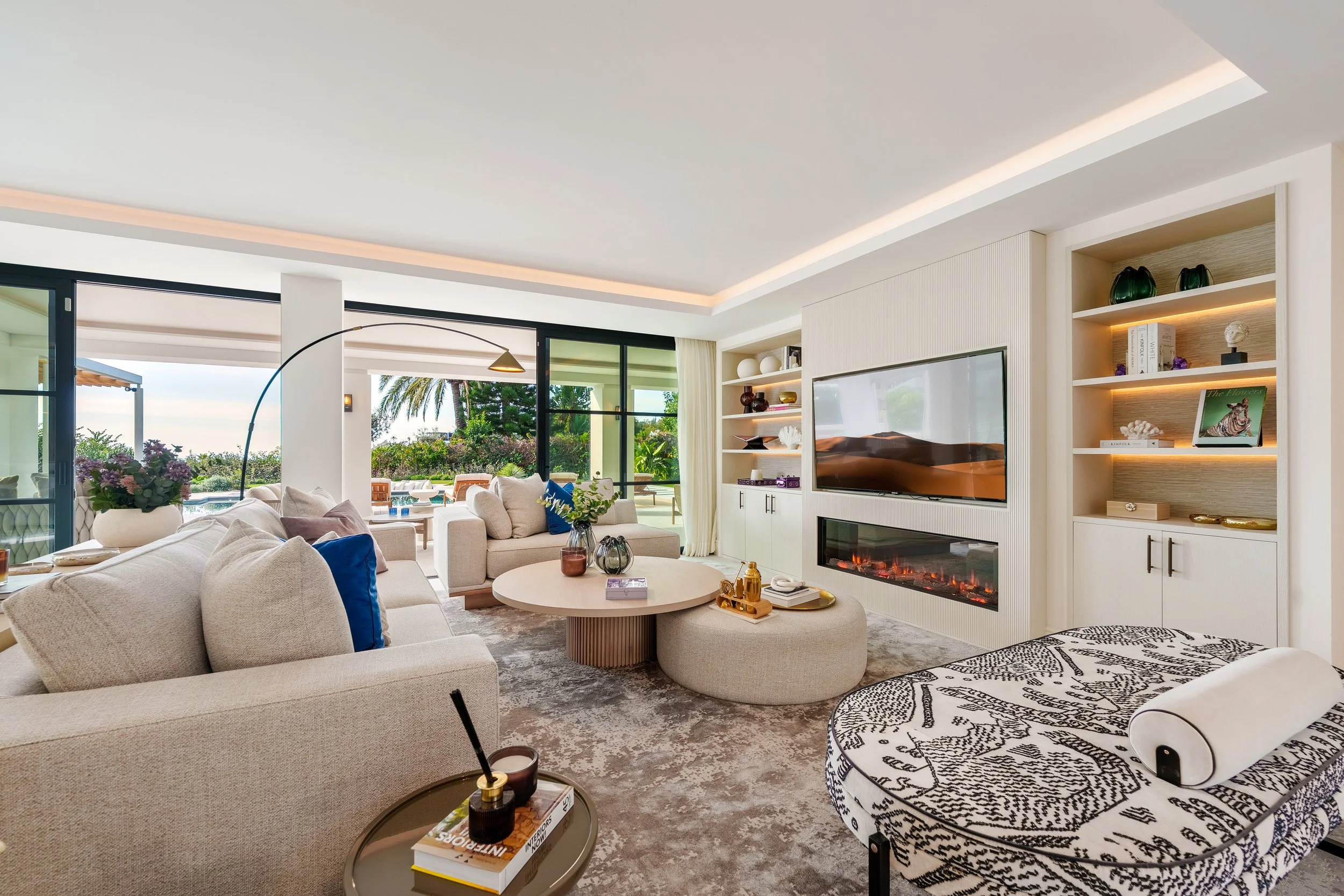 Open-Plan Living: A bright, airy living room featuring a sleek linear fireplace, recessed lighting, and direct access to the terrace.