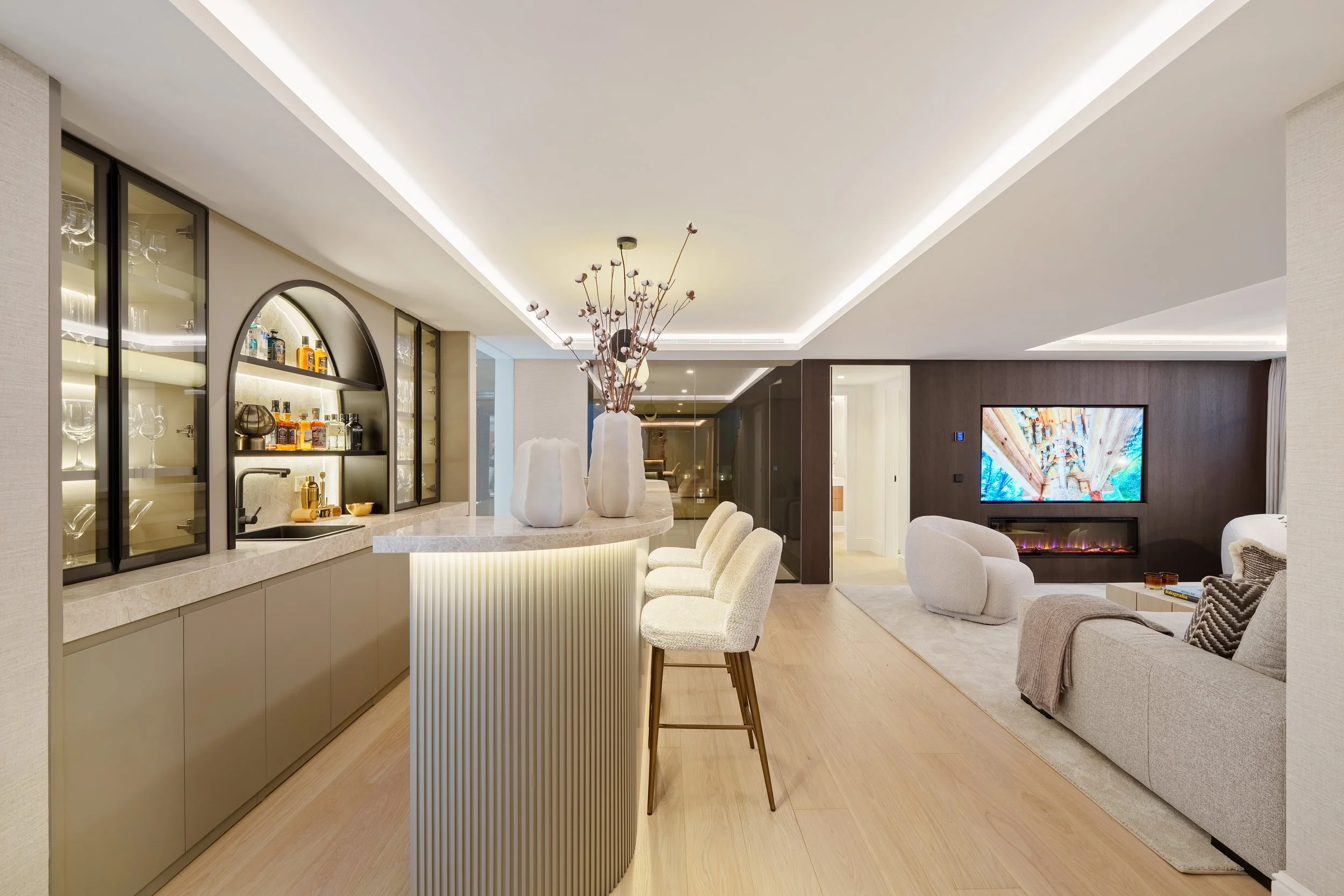 Bar &amp; Entertainment: A stylish home bar and entertainment lounge, featuring custom backlit cabinetry and a marble-clad serving island.