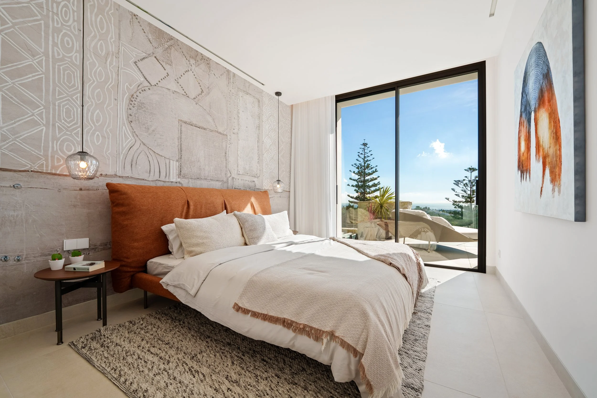 A beautifully appointed bedroom on the lower level with a private garden patio and floor-to-ceiling windows.