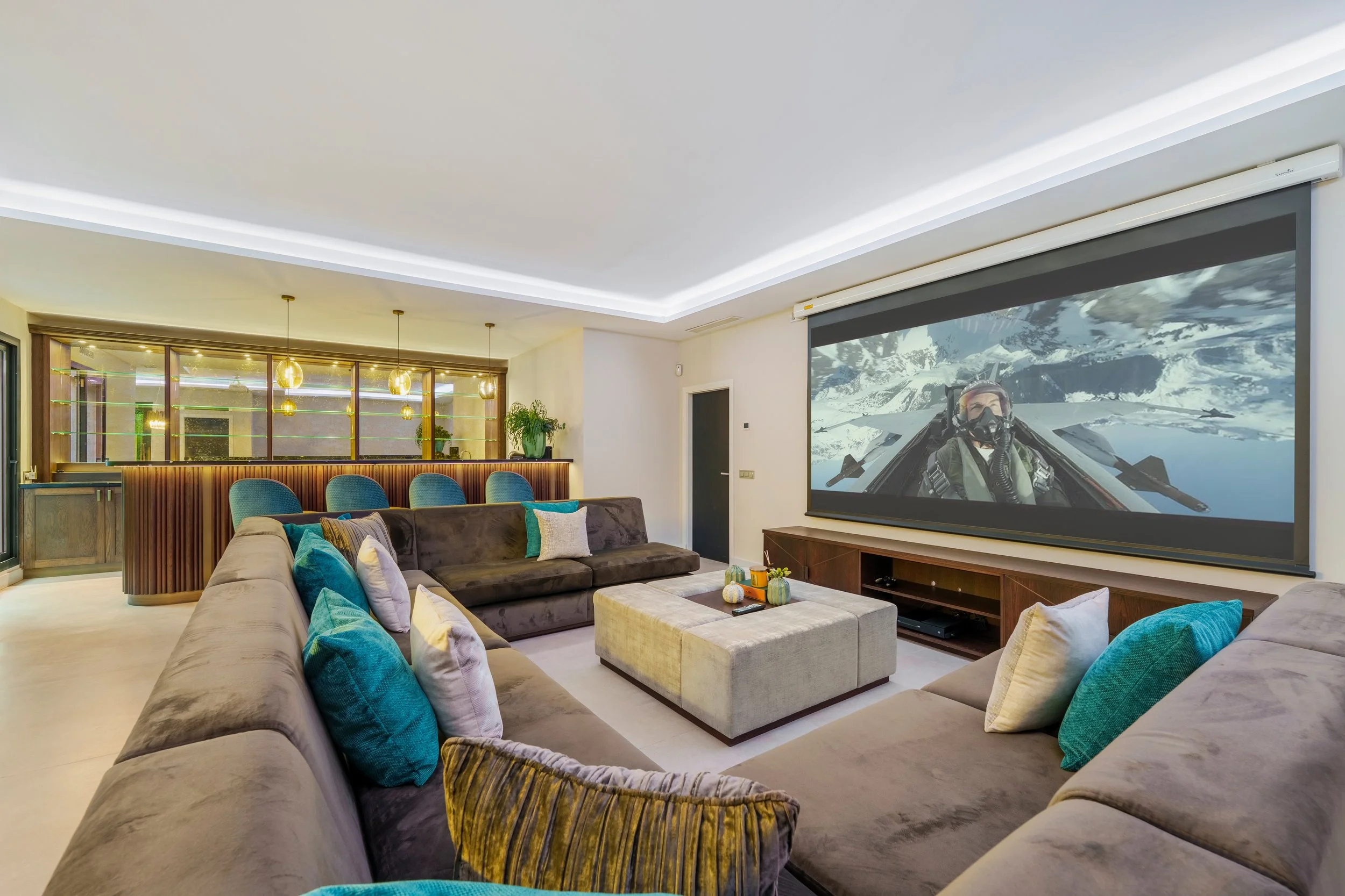 Professional cinema-style entertainment room with a large projector screen and plush seating.