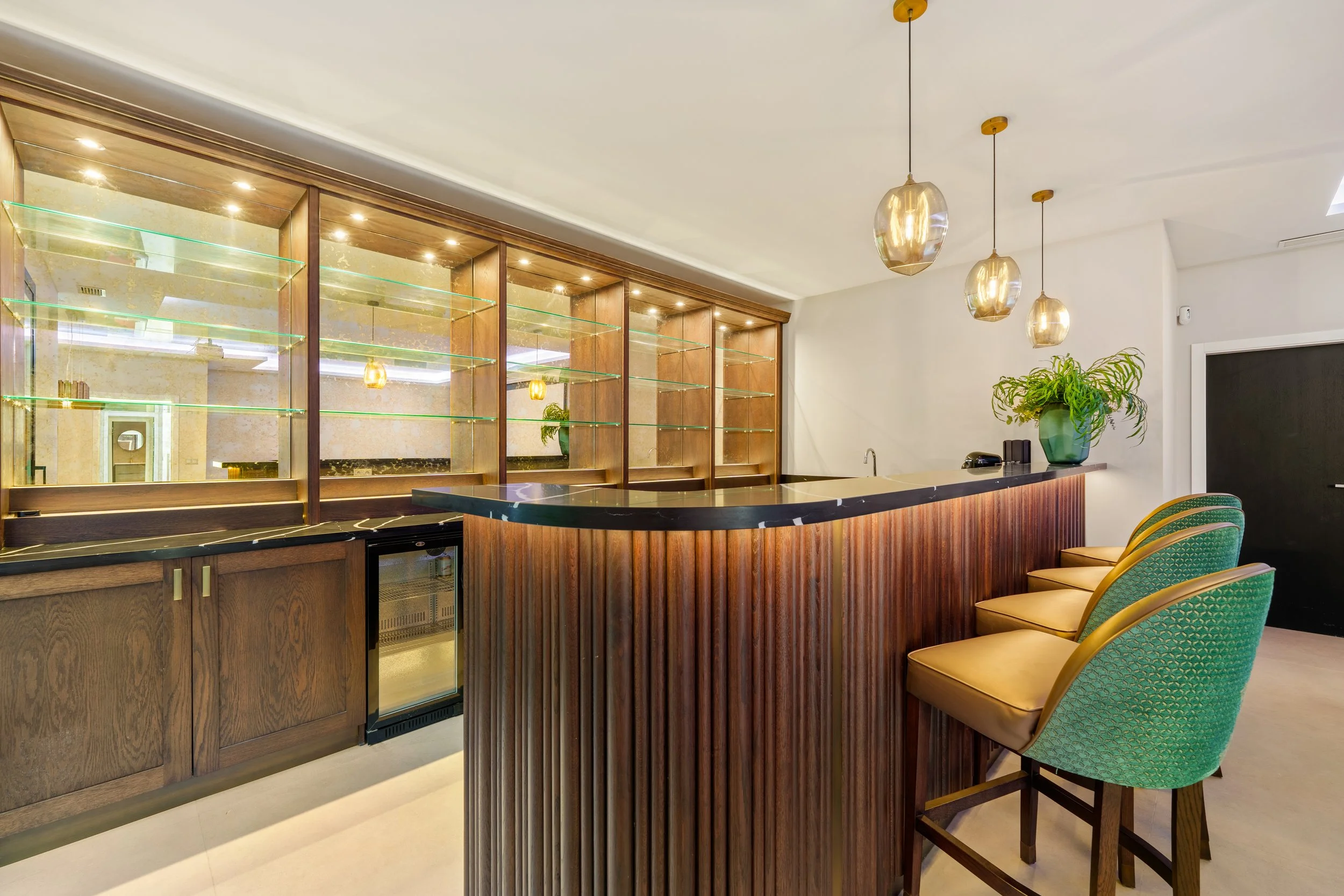 Custom-designed wood-paneled bar area located within the villa's lower-level entertainment suite.