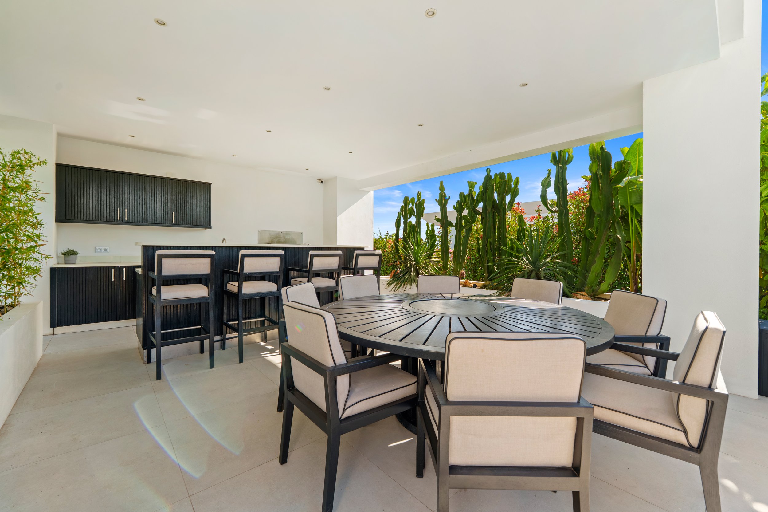 Covered outdoor dining area and terrace bar designed for Mediterranean entertaining.