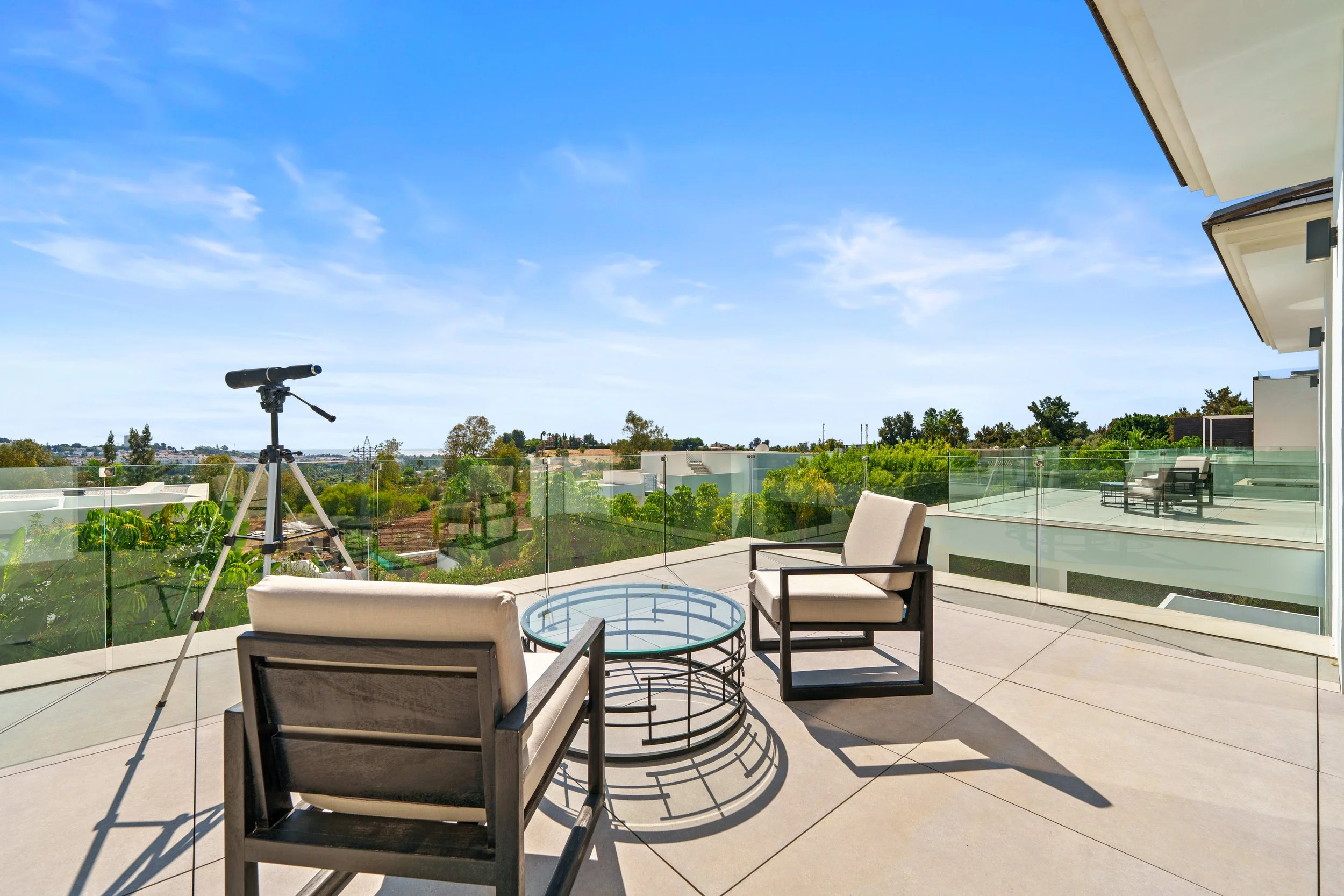 Upper-level terrace with designer outdoor furniture and panoramic views of the surroundings.