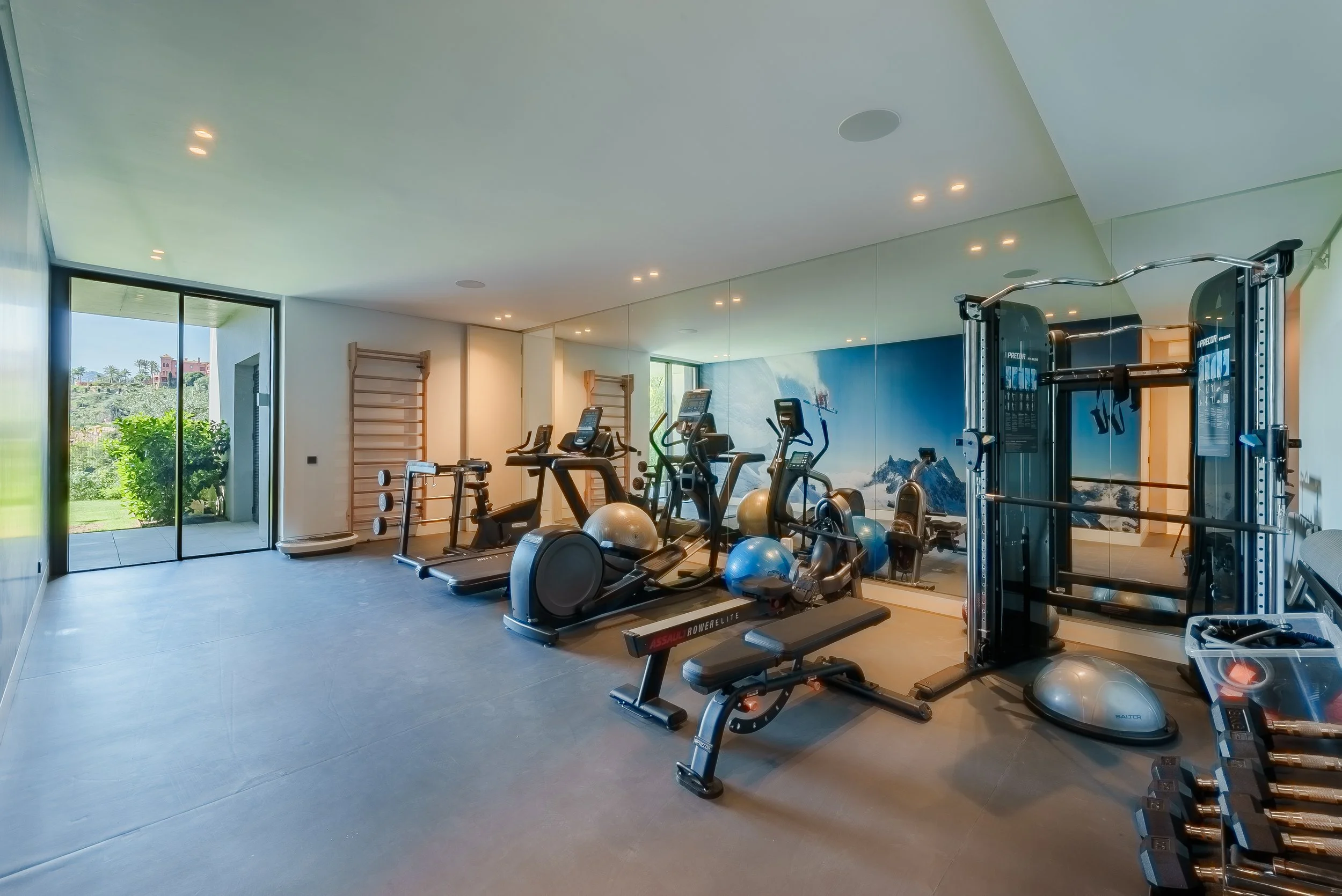 Large private gym equipped with high-end cardio machines and weights.