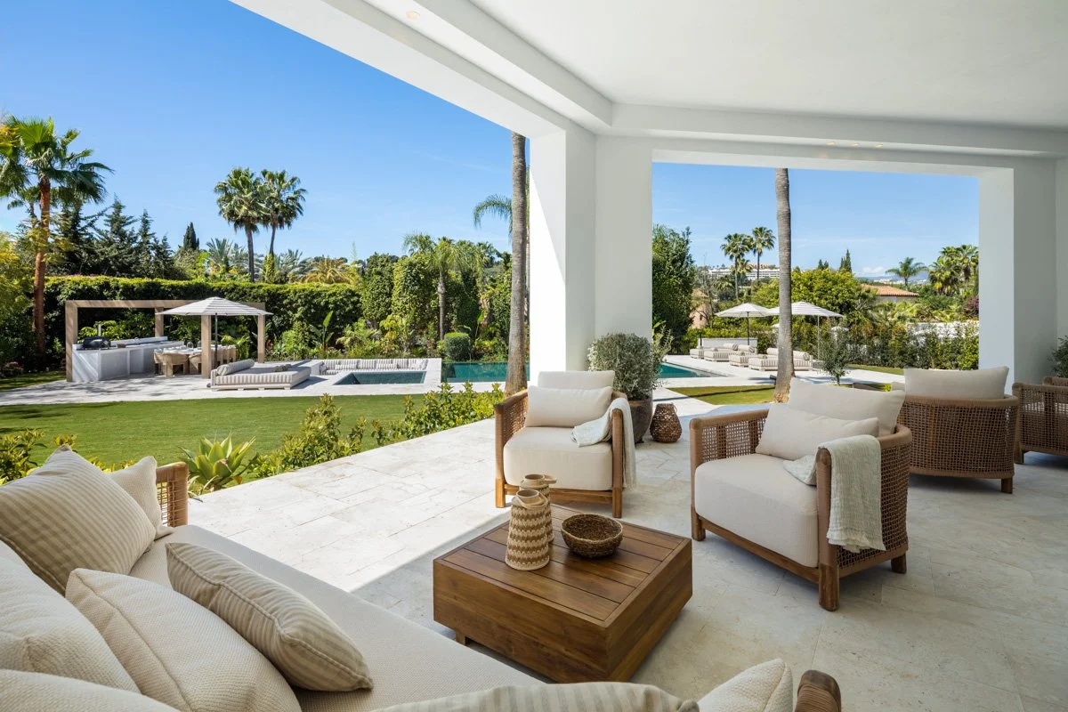 Large covered terrace with high-end outdoor furniture and views of the Marbella Golf Valley.