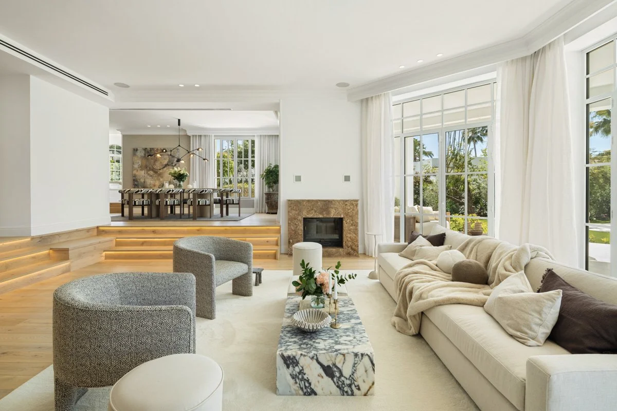 Bright open-plan living room with plush neutral seating and fireplace in Nueva Andalucia villa.